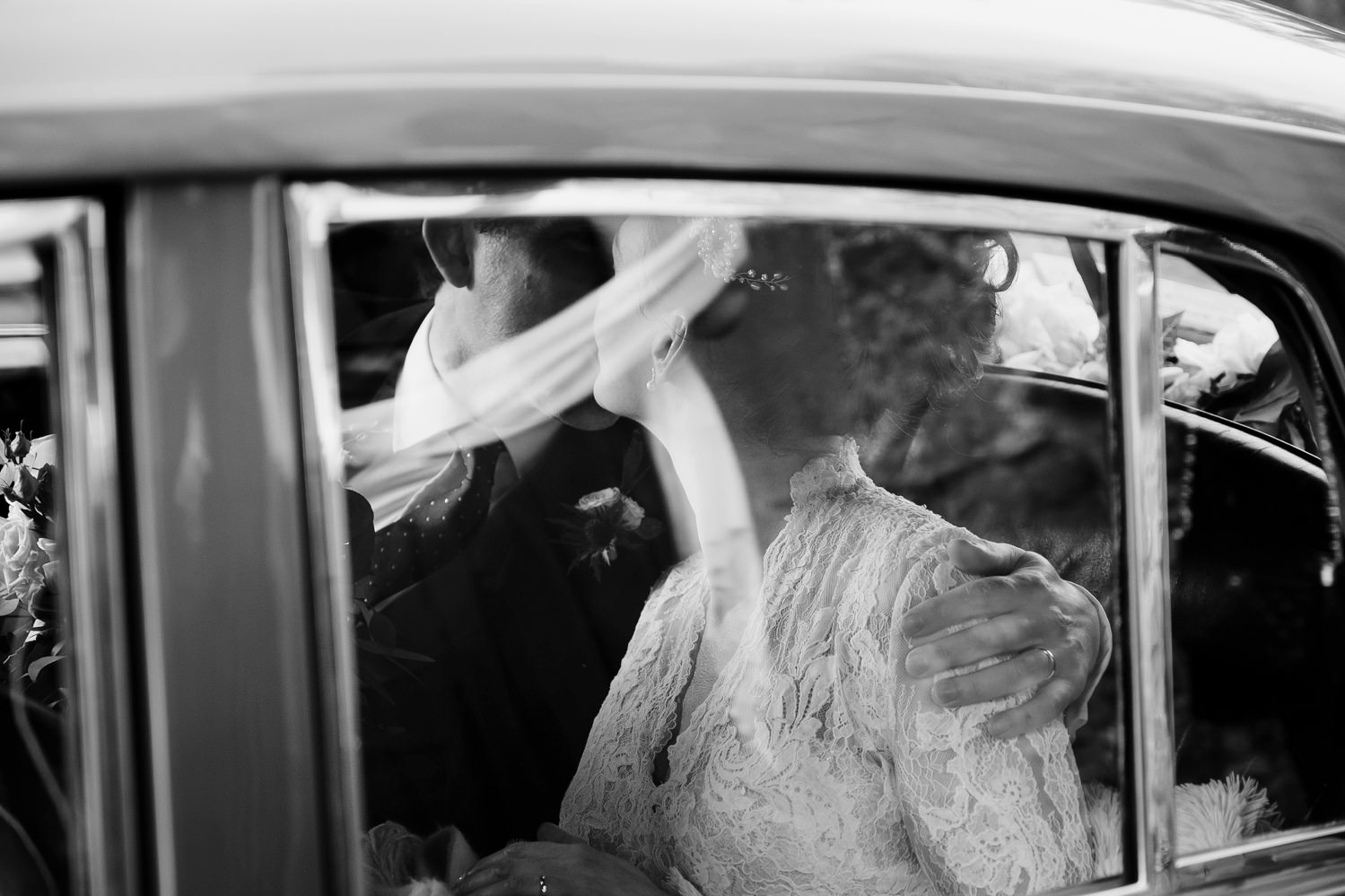  Bride and groom kiss in back seat of classic Bentley 