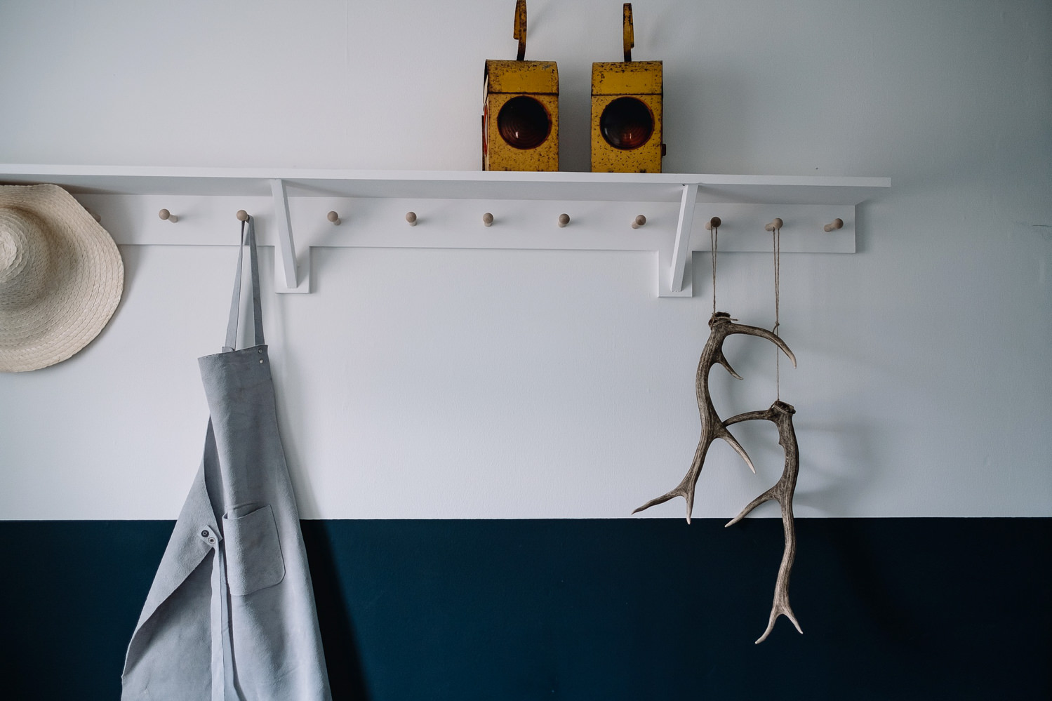 Stag antlers hang alongside an apron on the coat hook in the boot room.