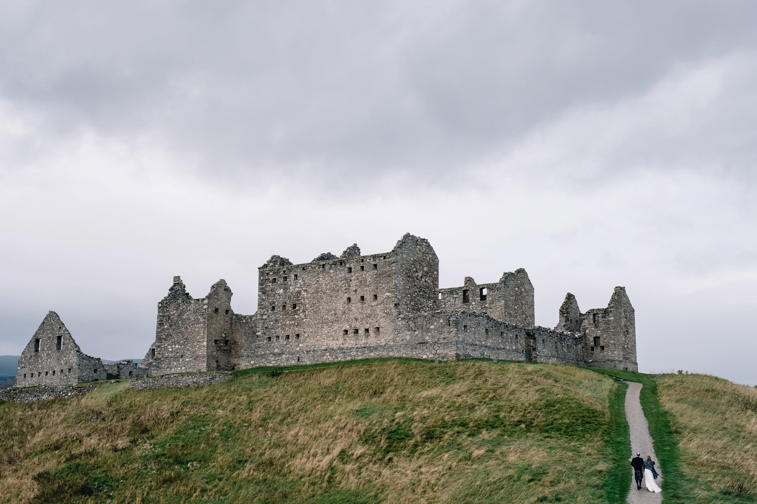 Bride and groom walking up to Ruthven Barracks