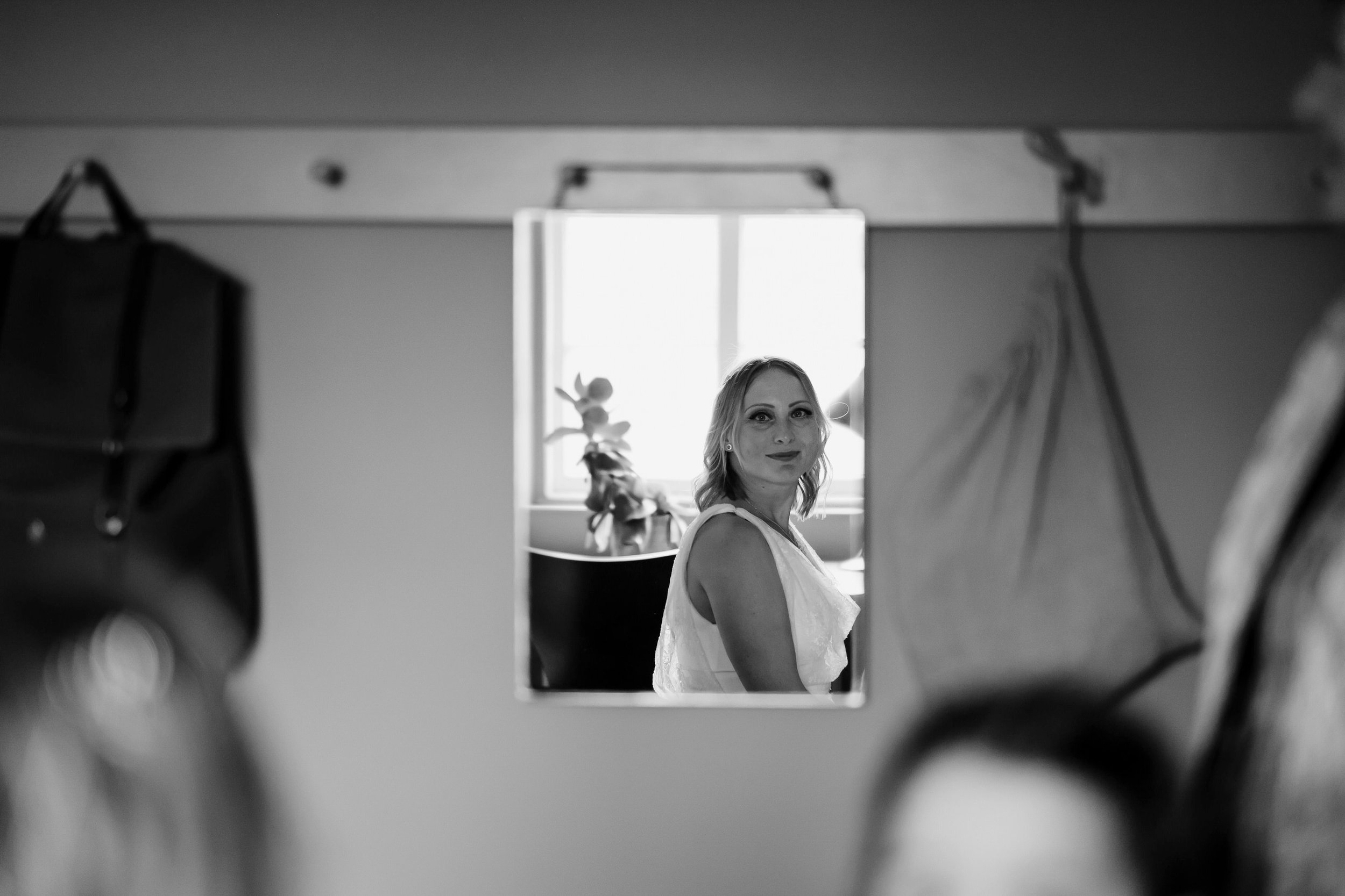  Bride looks at herself in the mirror. 