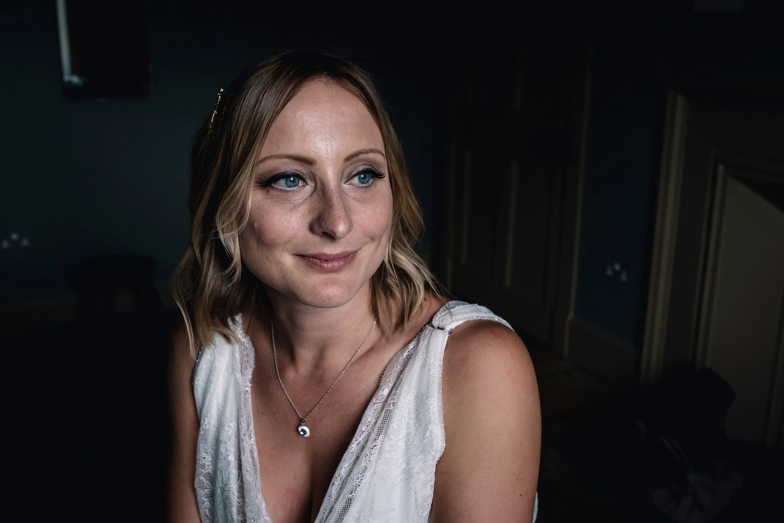  Bride looks past the camera, out of the window. 