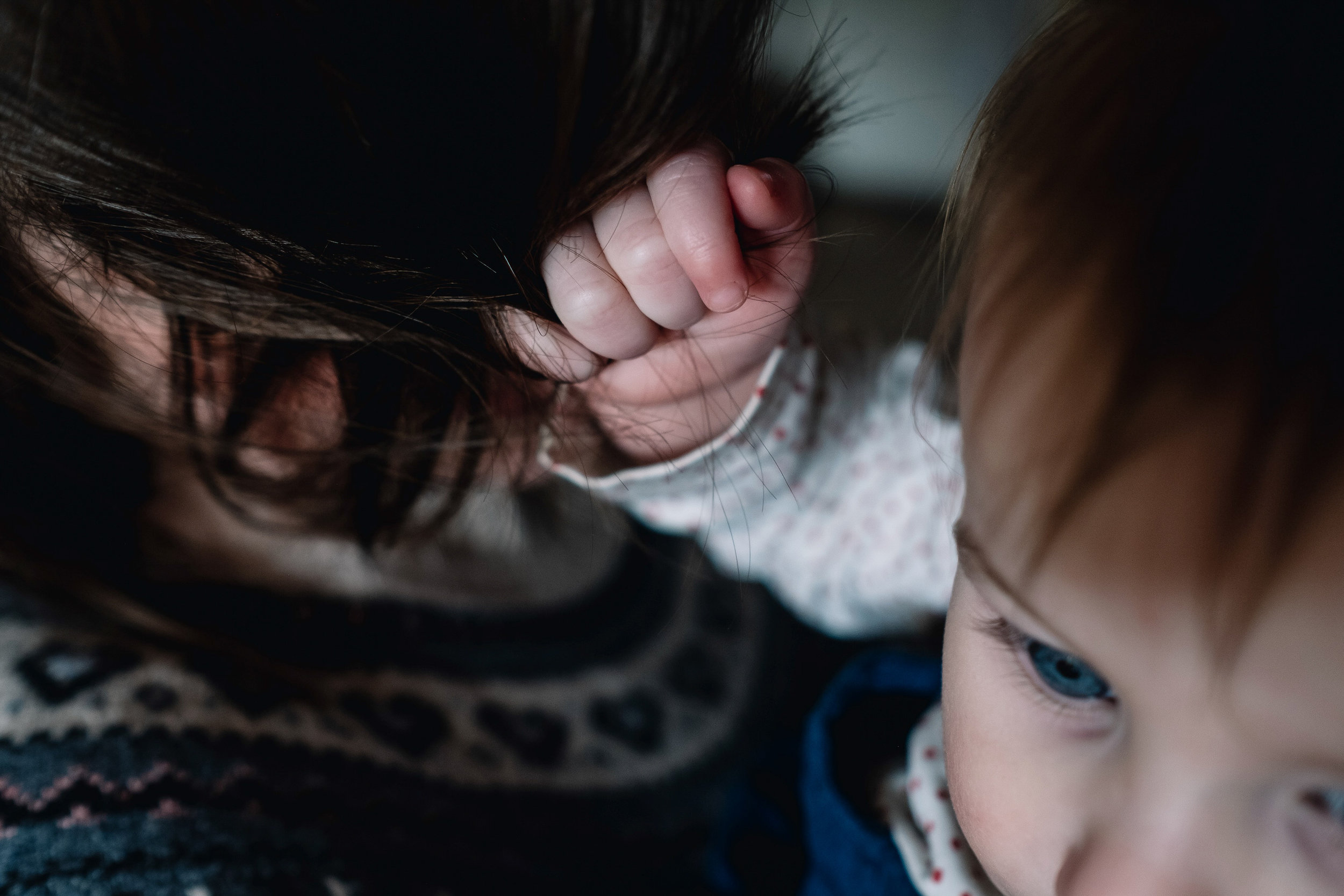  Little girl grabbing hold of her mother's hair. 