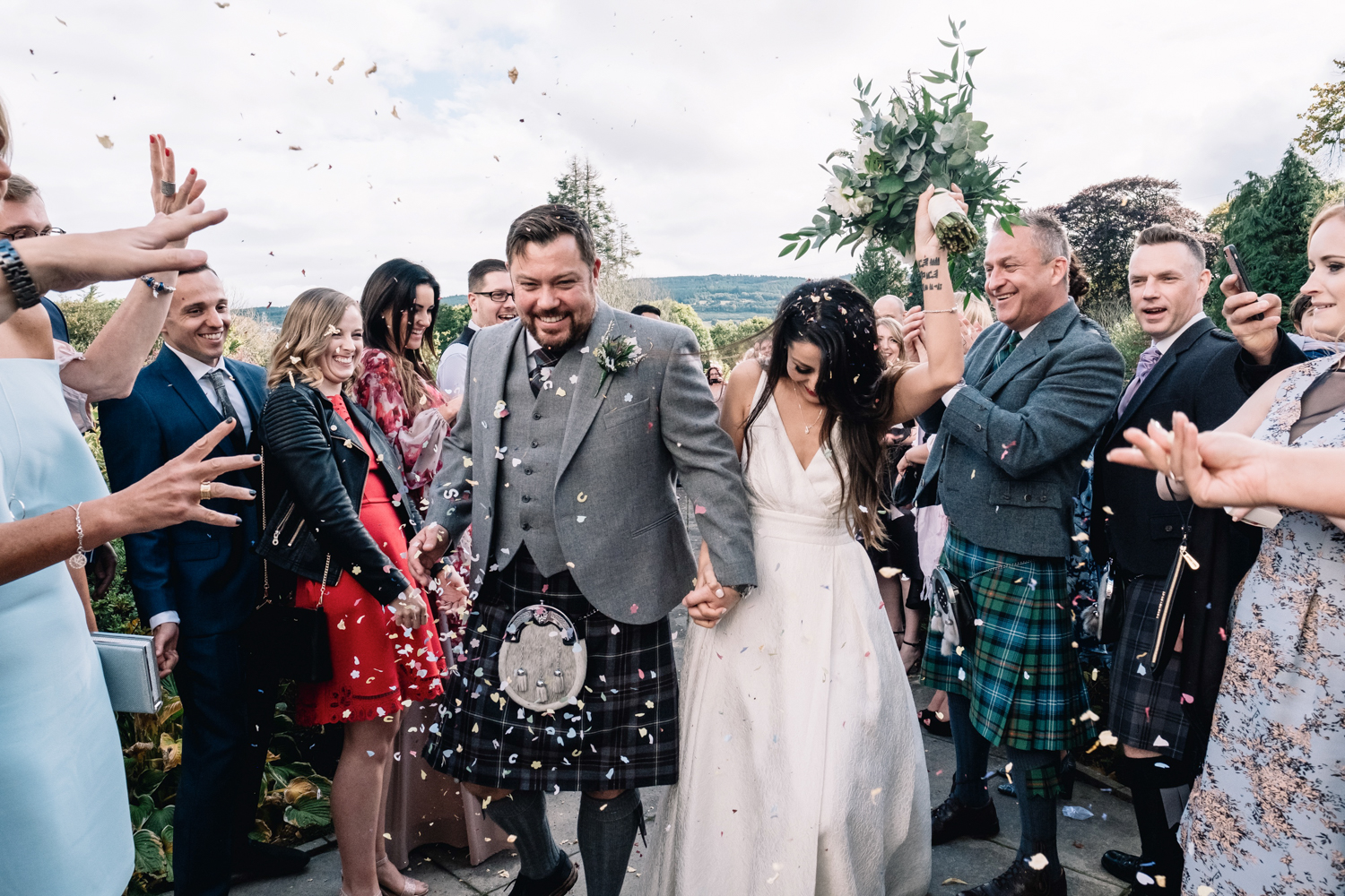  Guests throw confetti at bride and groom. 