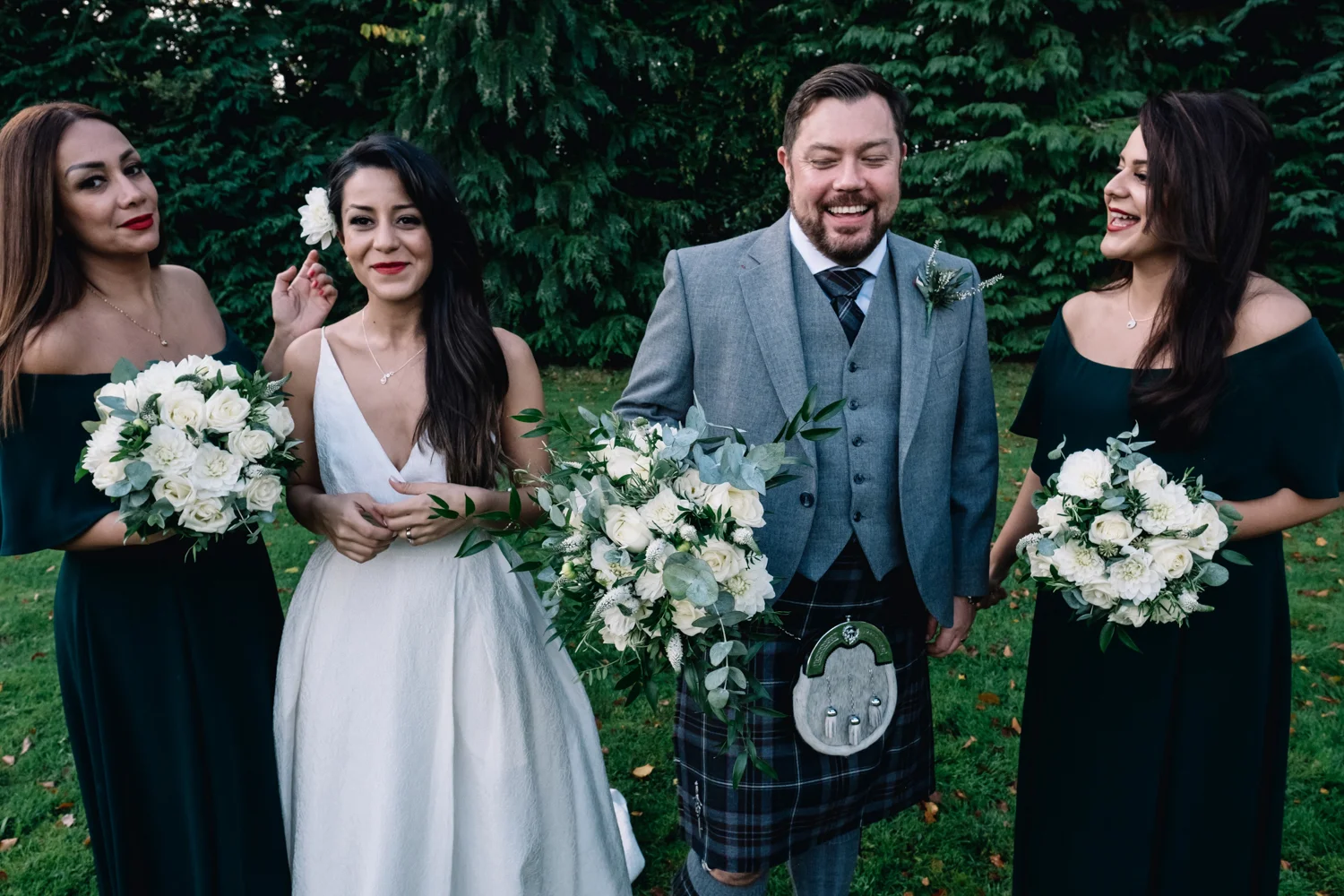  Bride and groom laugh with the two bridesmaids. 