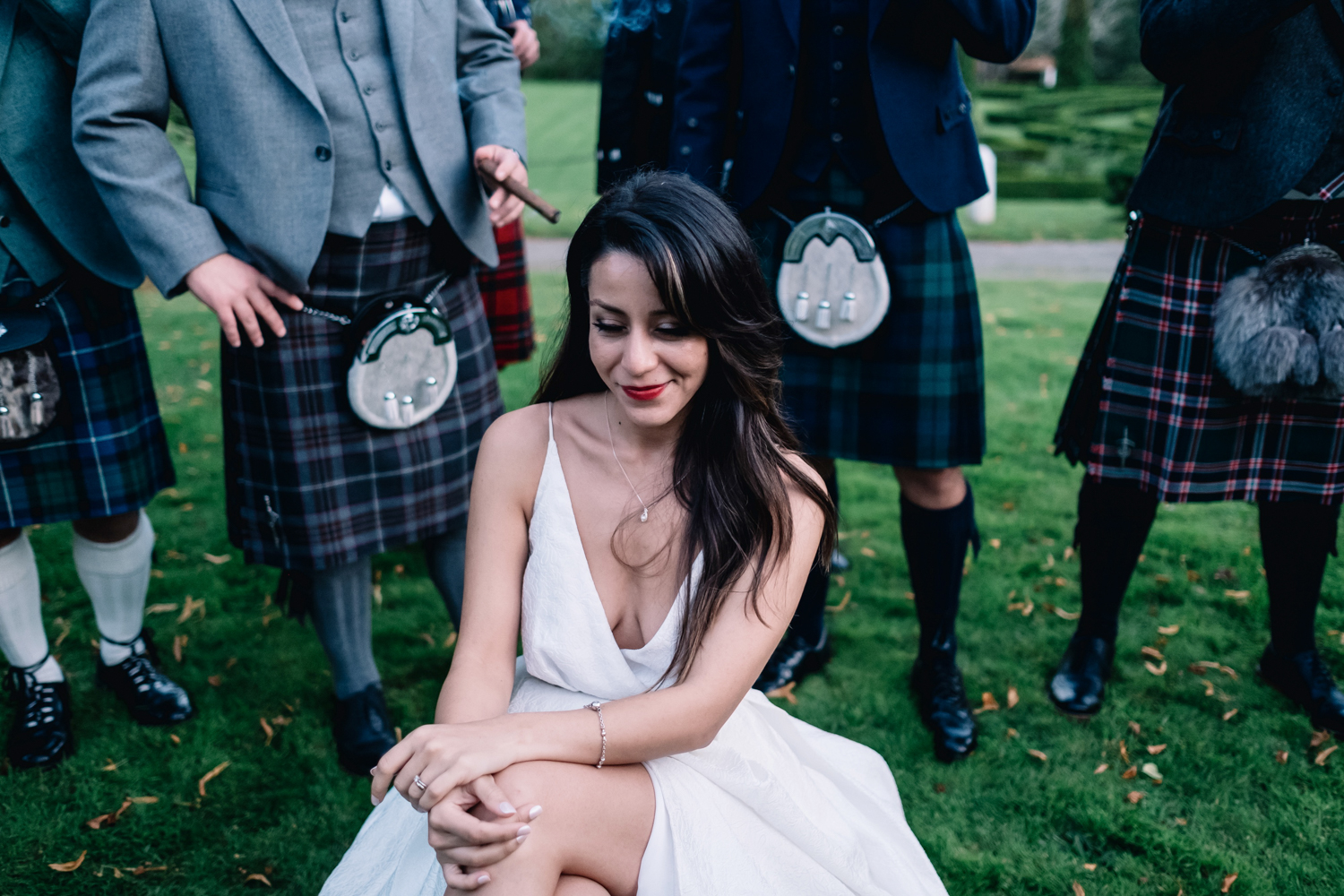 Bride sitting down whilst surrounded by smoking guests.