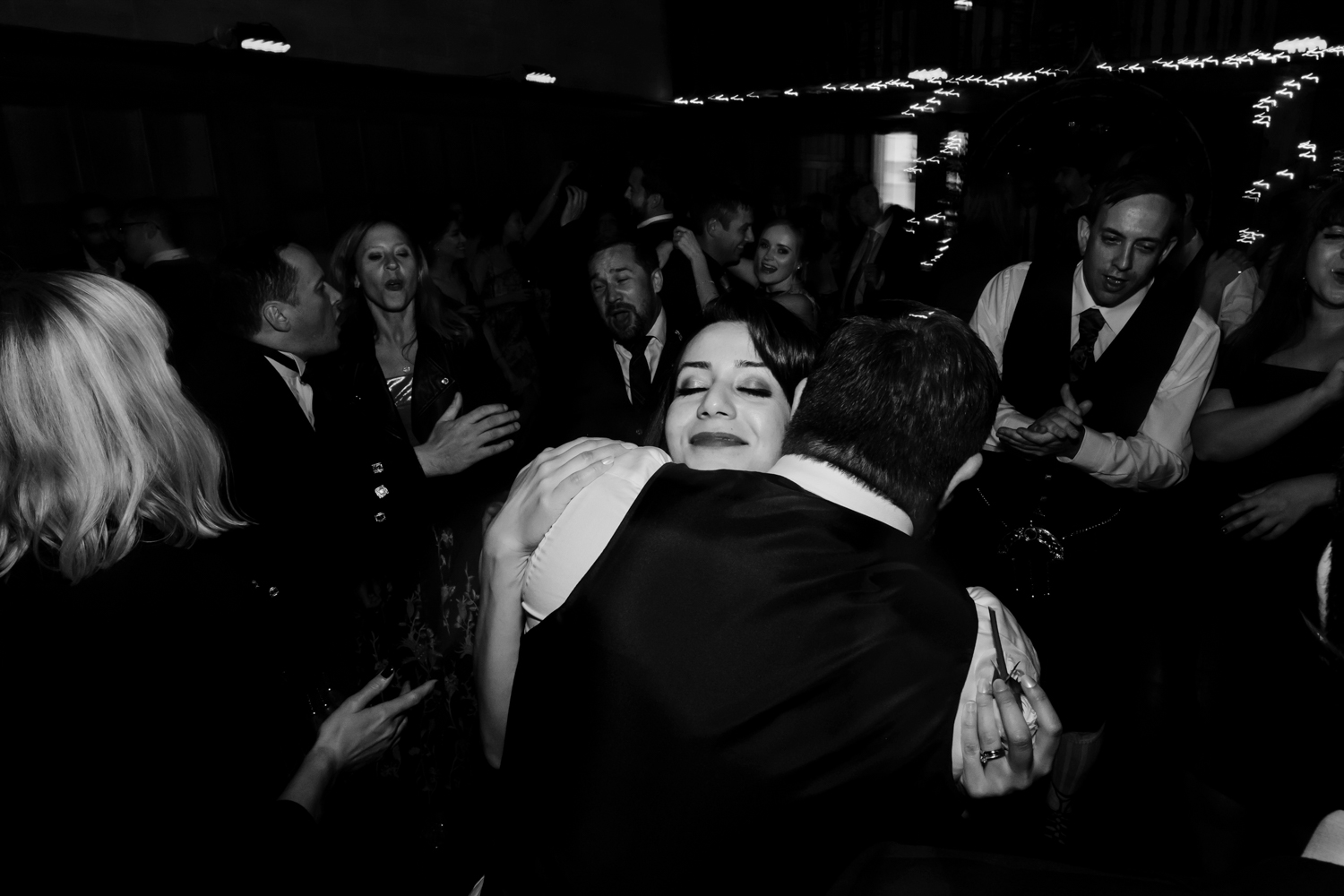  Bride and groom hug on the dance floor. 