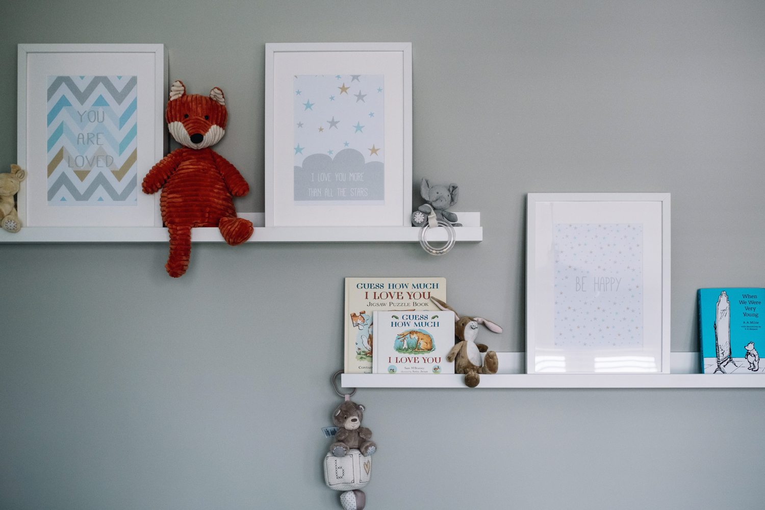 Wall of nursery with prints + books.