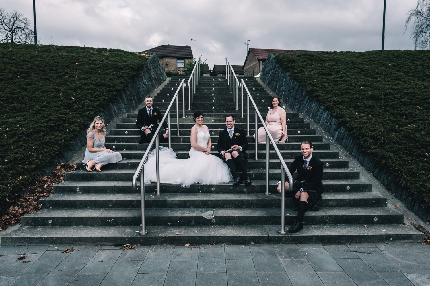 Bridal party sitting on stairs outside West on the Green.