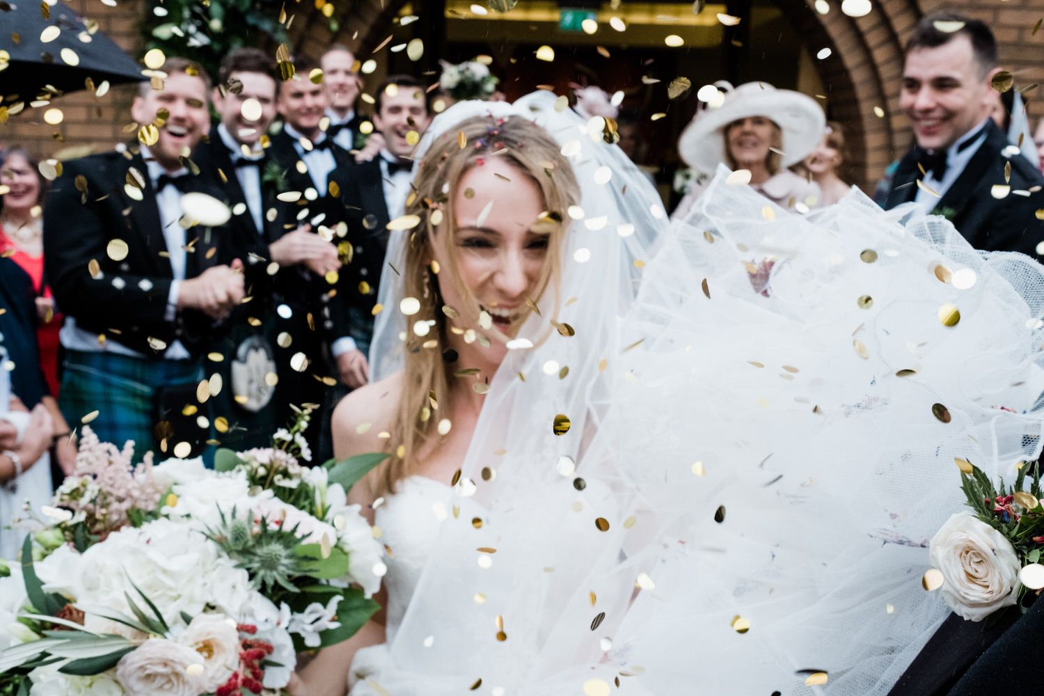  A close up and out of focus photograph of a bride covered with confetti. 