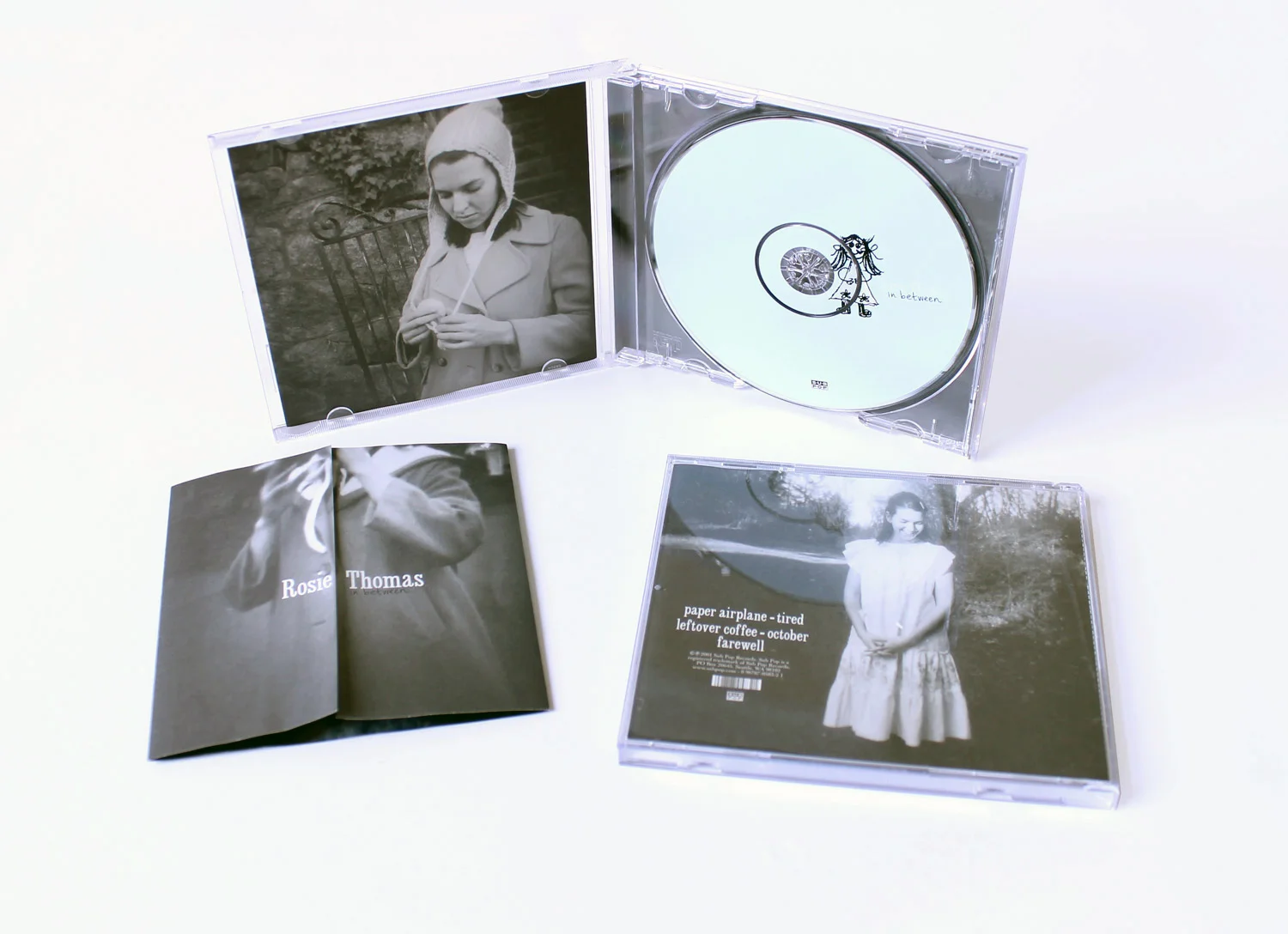 Rosie Thomas In Between EPAlthough the title for this EP came from the fact that it was released as a stop-gap between two full lengths, I redefined the title. By splitting the front cover down the middle--along the opening of her jacket, the bookle…