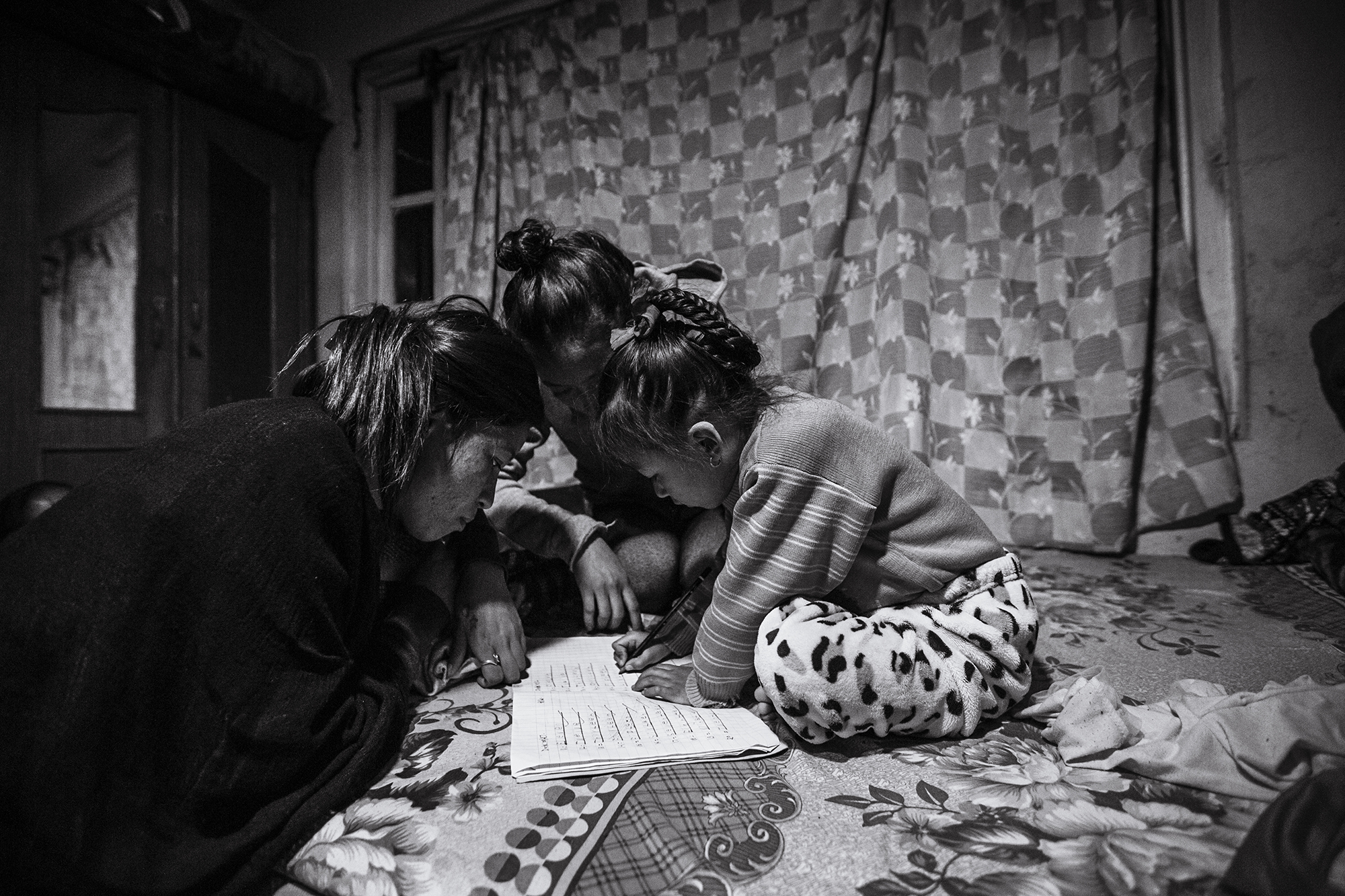 Anu and Anita help Anjika with her schoolwork.