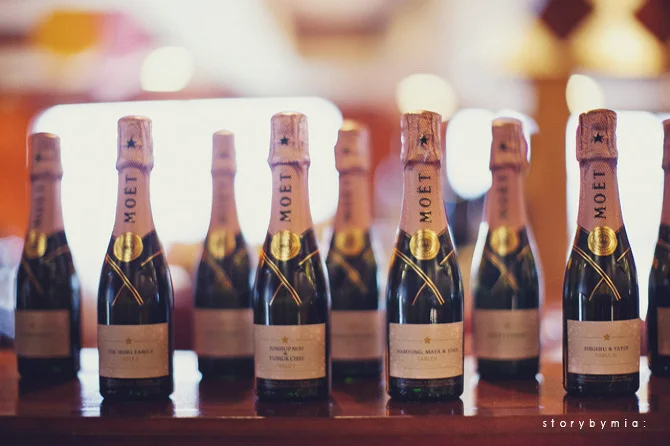 Mini Moet bottles with custom labels as escort cards.