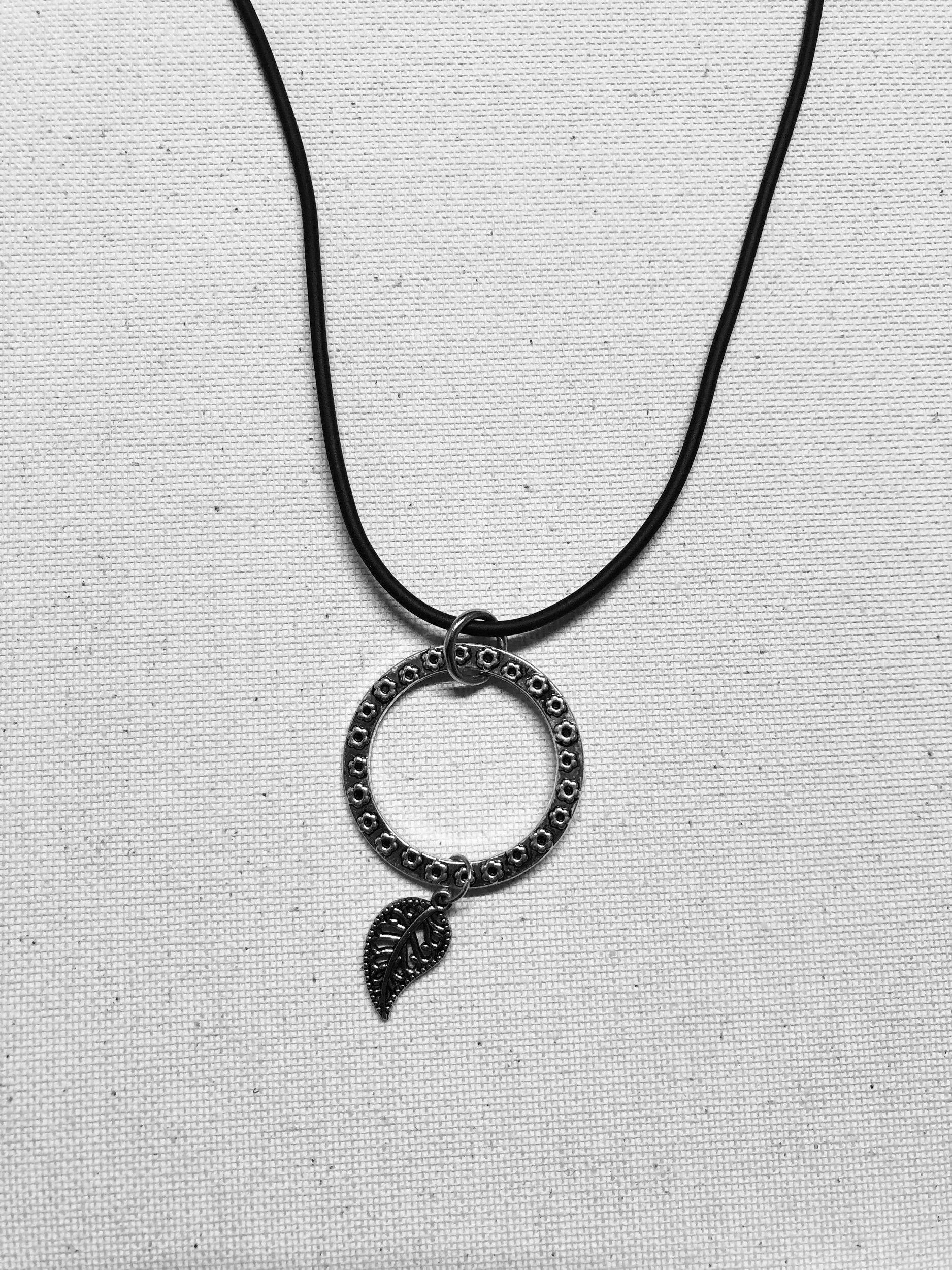 Small circular charm leaf cord necklace.
