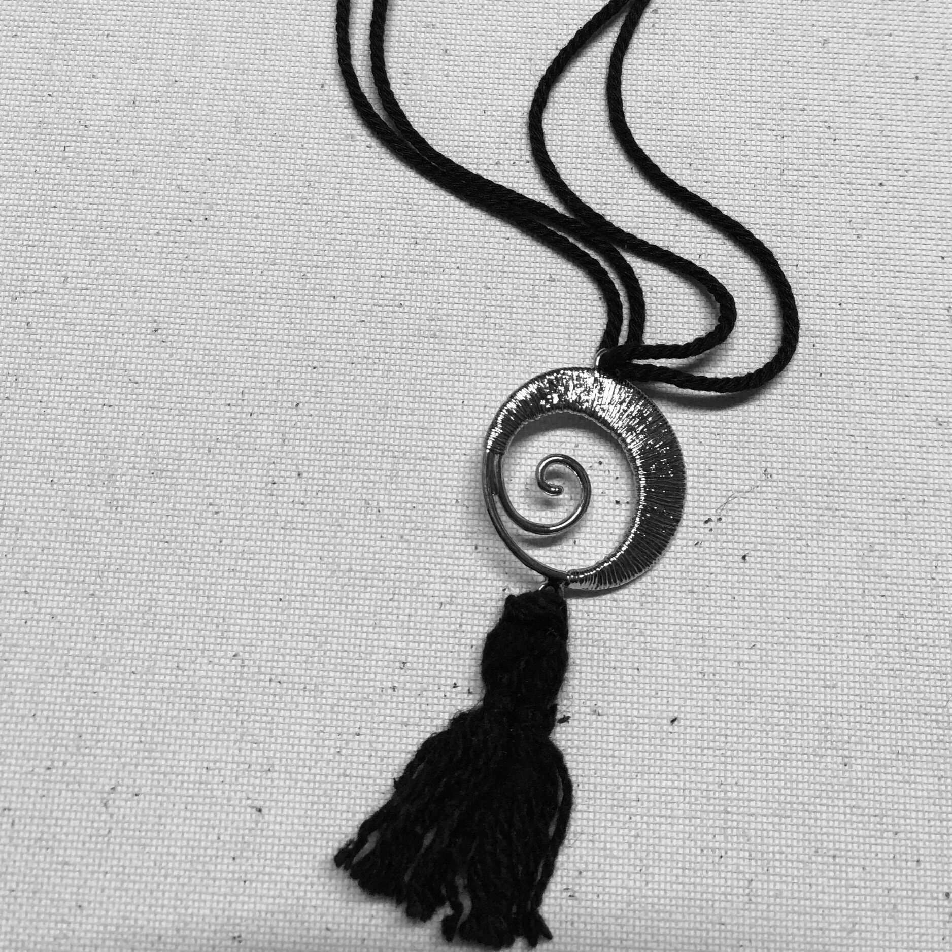A spiral metal and tassel necklace.