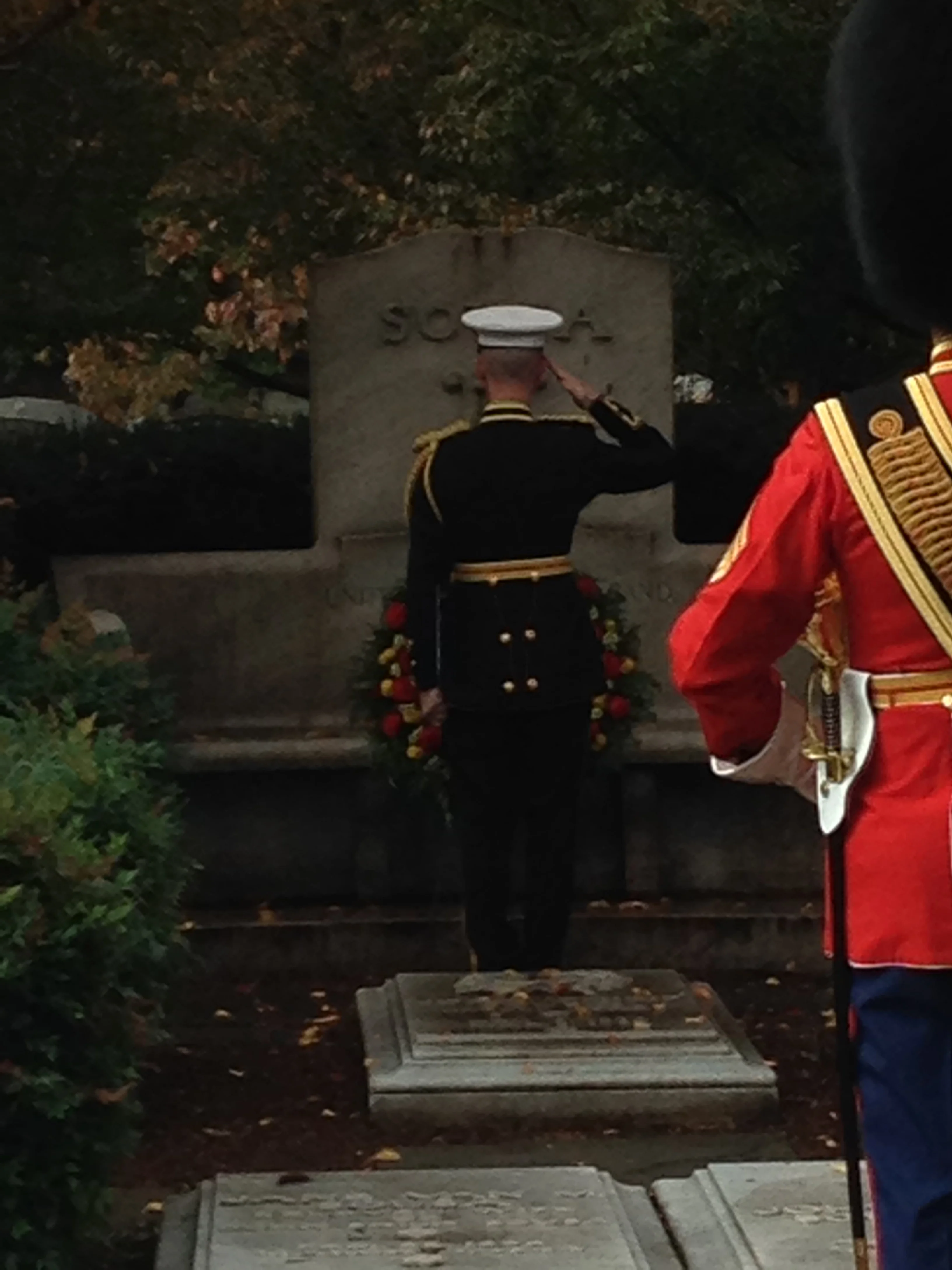 The leader of the band lays a wreath at Sousa's grave and offers a salute.