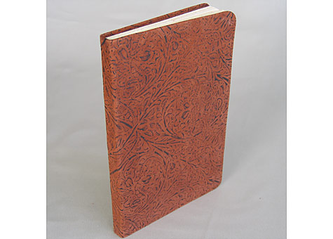 Binder: Lily Stevenson: Journal. The soft leather-bound blank book has handmade Iowa walnut fly leaves. The book block is Rives paper sewn on tapes. It is an experimental piece to see if embossed upholstery leather could be used to make a soft cover.