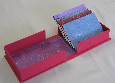 Binder: Lily Stevenson: Four Japanese Stab-bound Books in a Box. The red cloth-covered handmade box is lined with paper from Thailand. The set of four blank books is made from Thai mulberry paper.