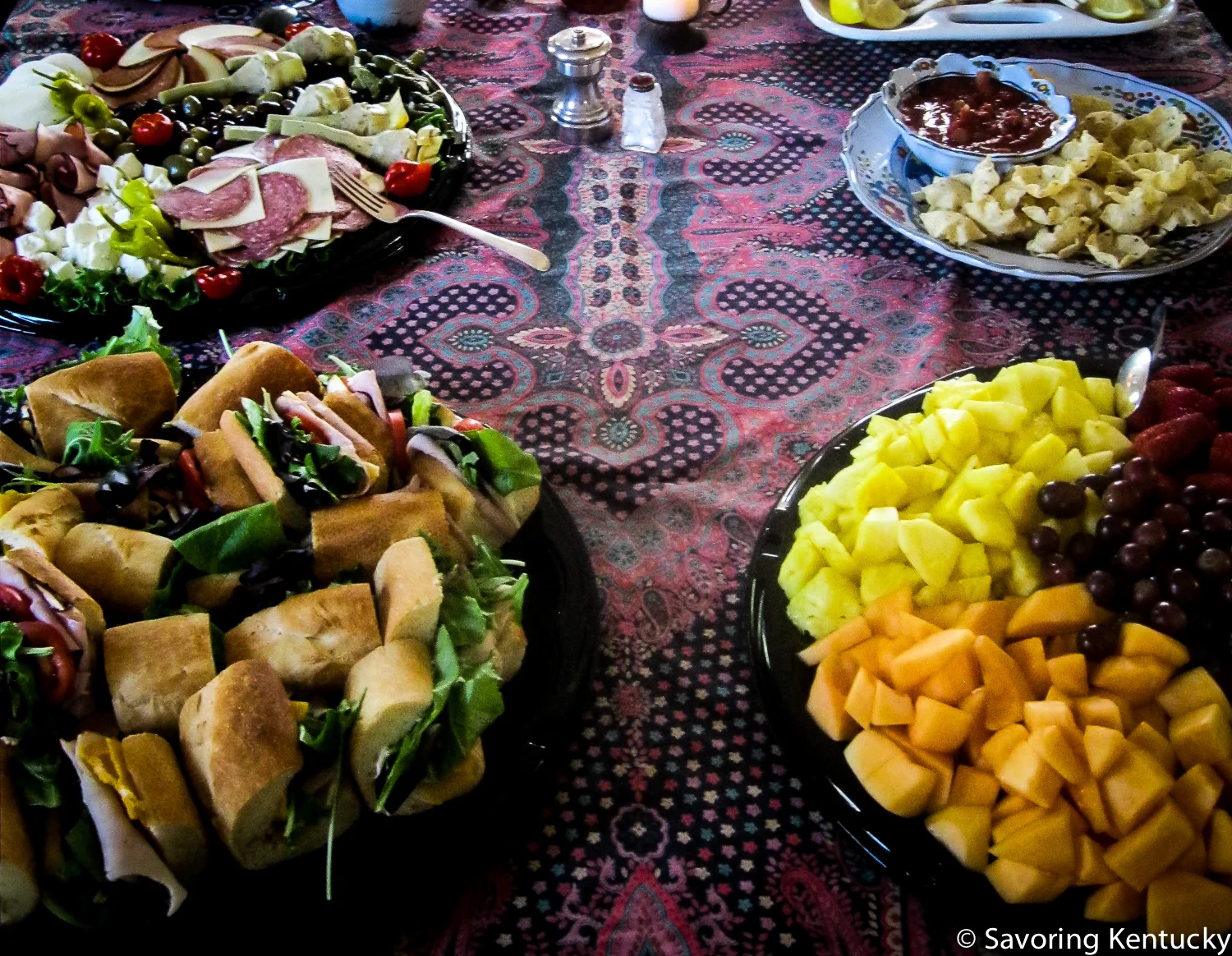 Good Foods antipasto platter, top left; mini-baguette sandwiches, lower left, large fruit tray bottom right