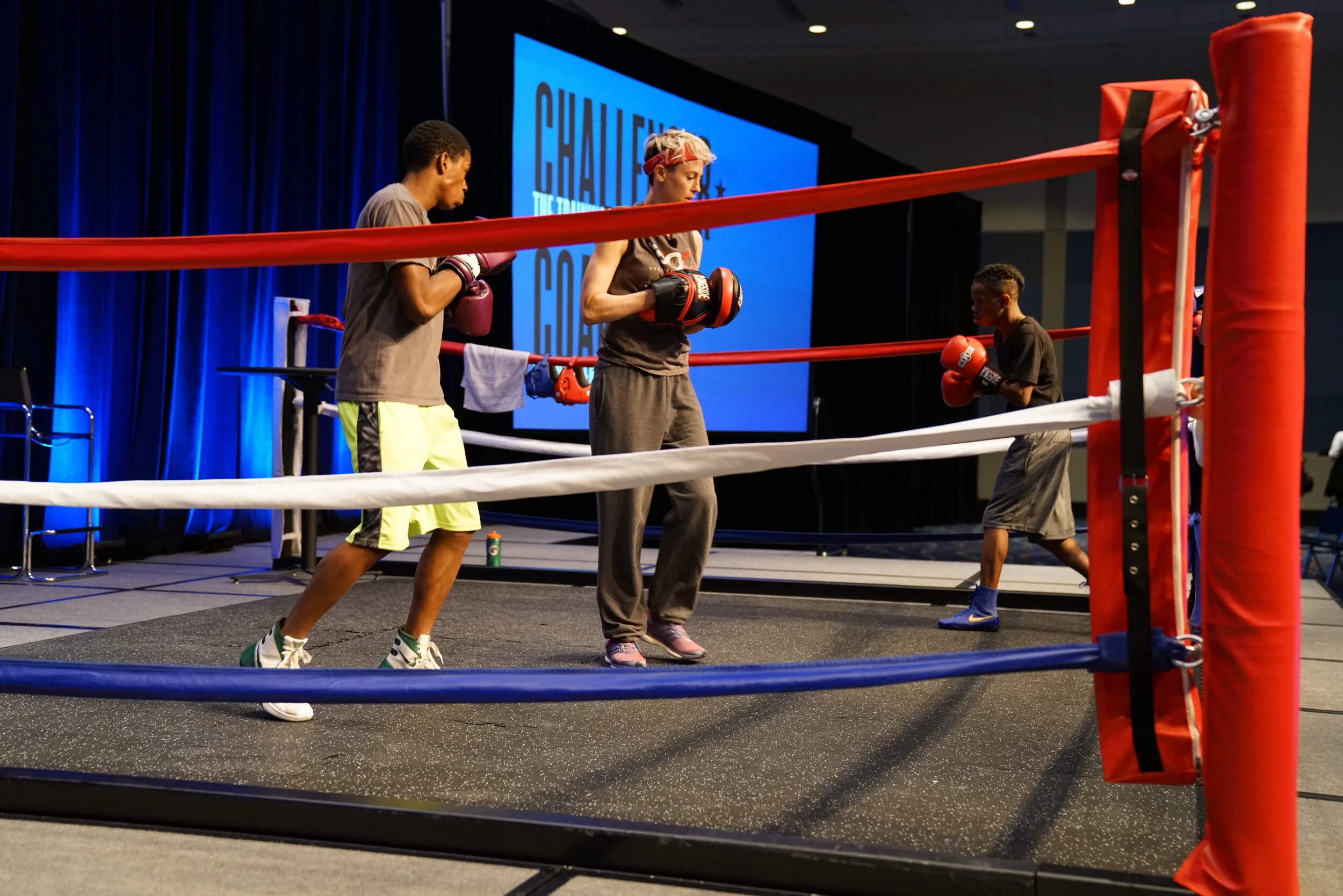 In order to truly embody the theme of Challenger Coaching, we relied on boxing as a metaphor. More specifically, the role of a coach in the sport. When the attendees entered the space, they heard Kanye West playing and saw a boxing ring, with a coac…