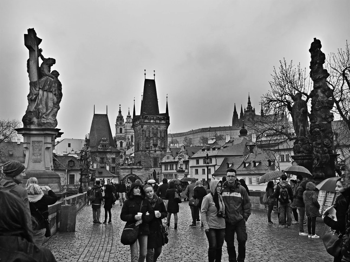 Pedestrians on Charle's Bridge are watched closely by statues of religious figures and royalty.