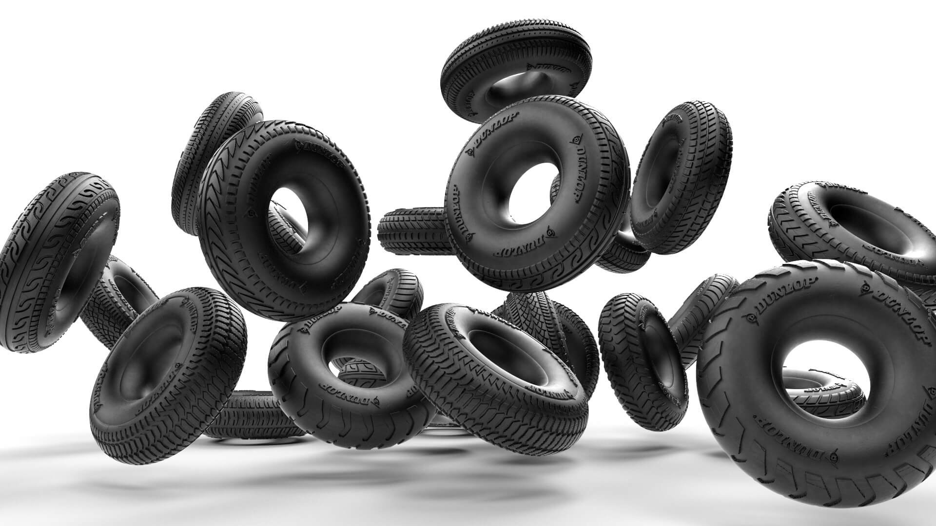 Dynamic 3D visual of multiple Dunlop tyres in motion against a white background, exploring form, texture, and rubber surface detailing.