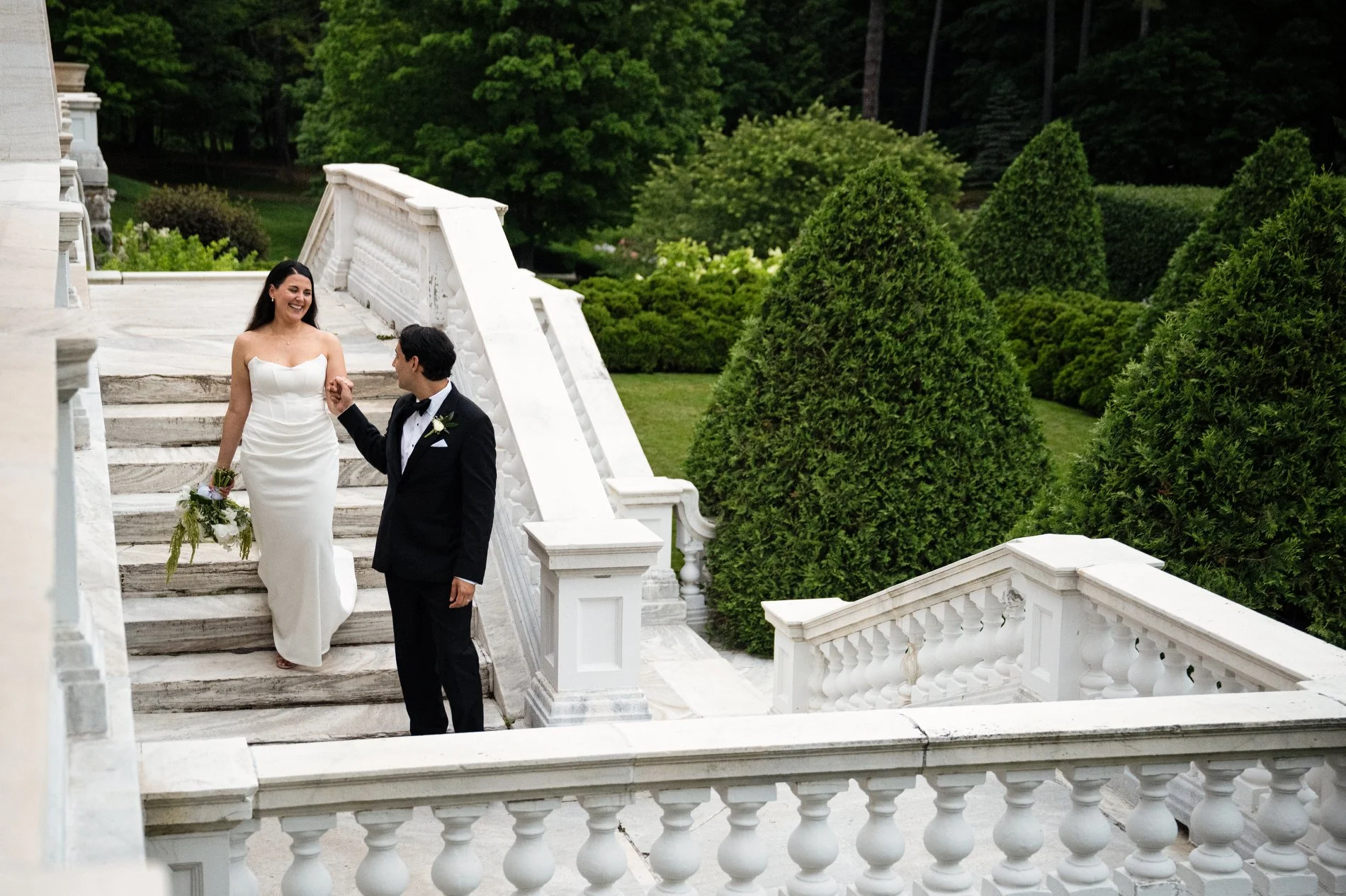 A couple walks down the grand staircase of The Mount during their romantic wedding in the Berkshires.