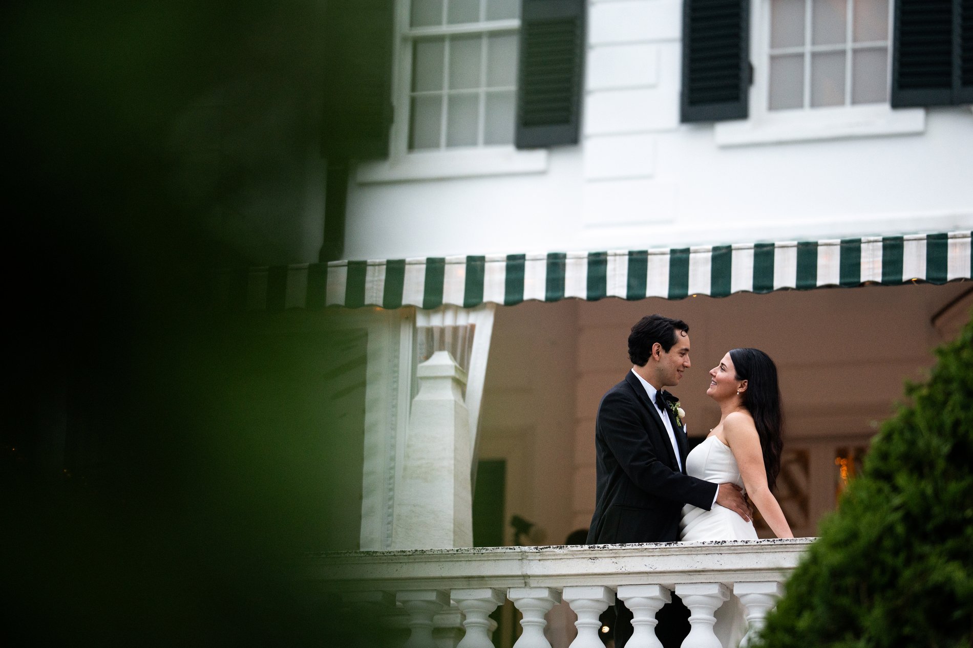 A couple poses on the terrace of The Mount during their romantic wedding in the Berkshires.
