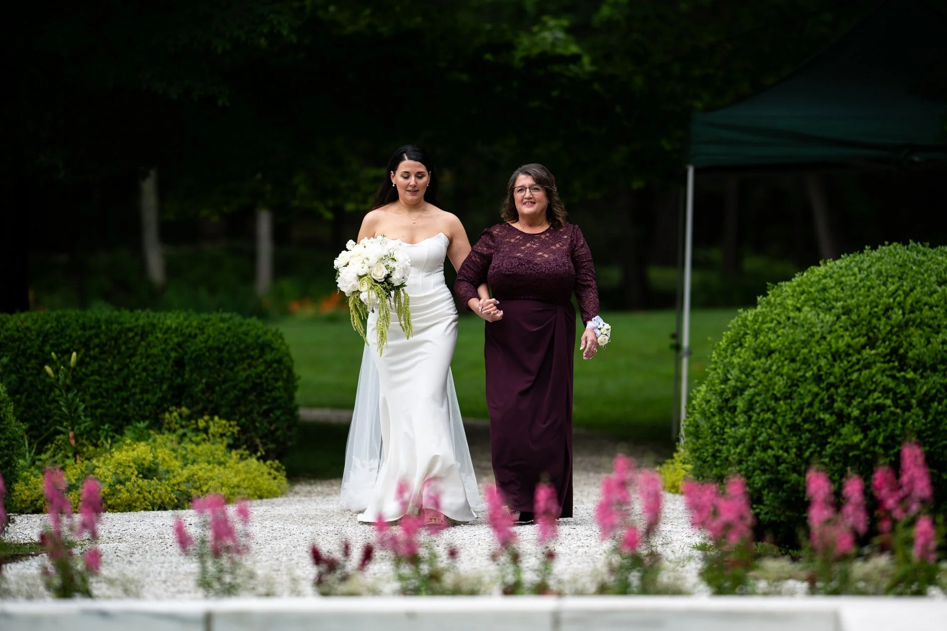 A bride walks down the aisle with her mom during her wedding at The Mount in Lenox, Massachusetts.