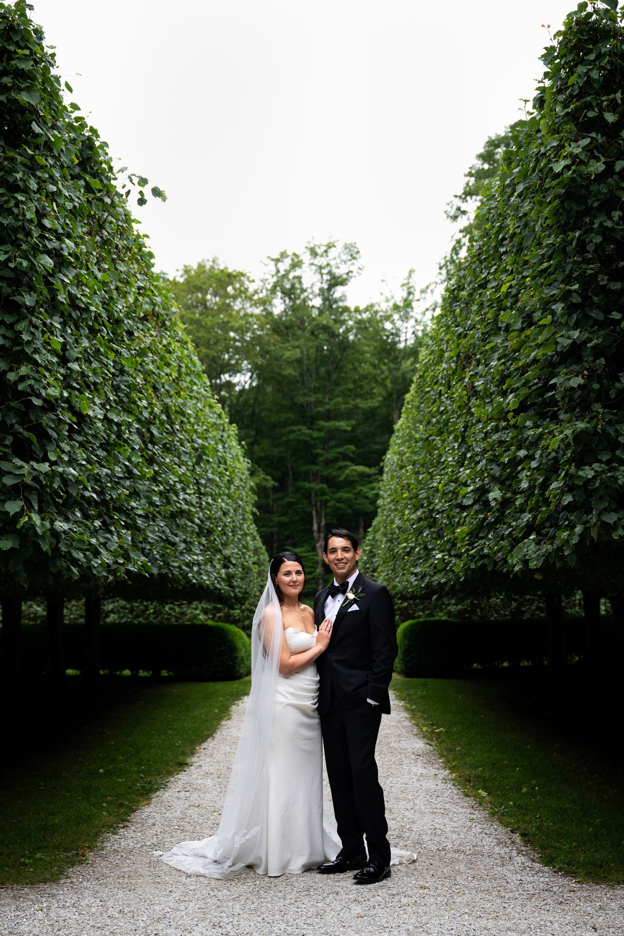 A bride and groom pose in the Lime Walk at The Mount during their romantic Berkshires wedding.