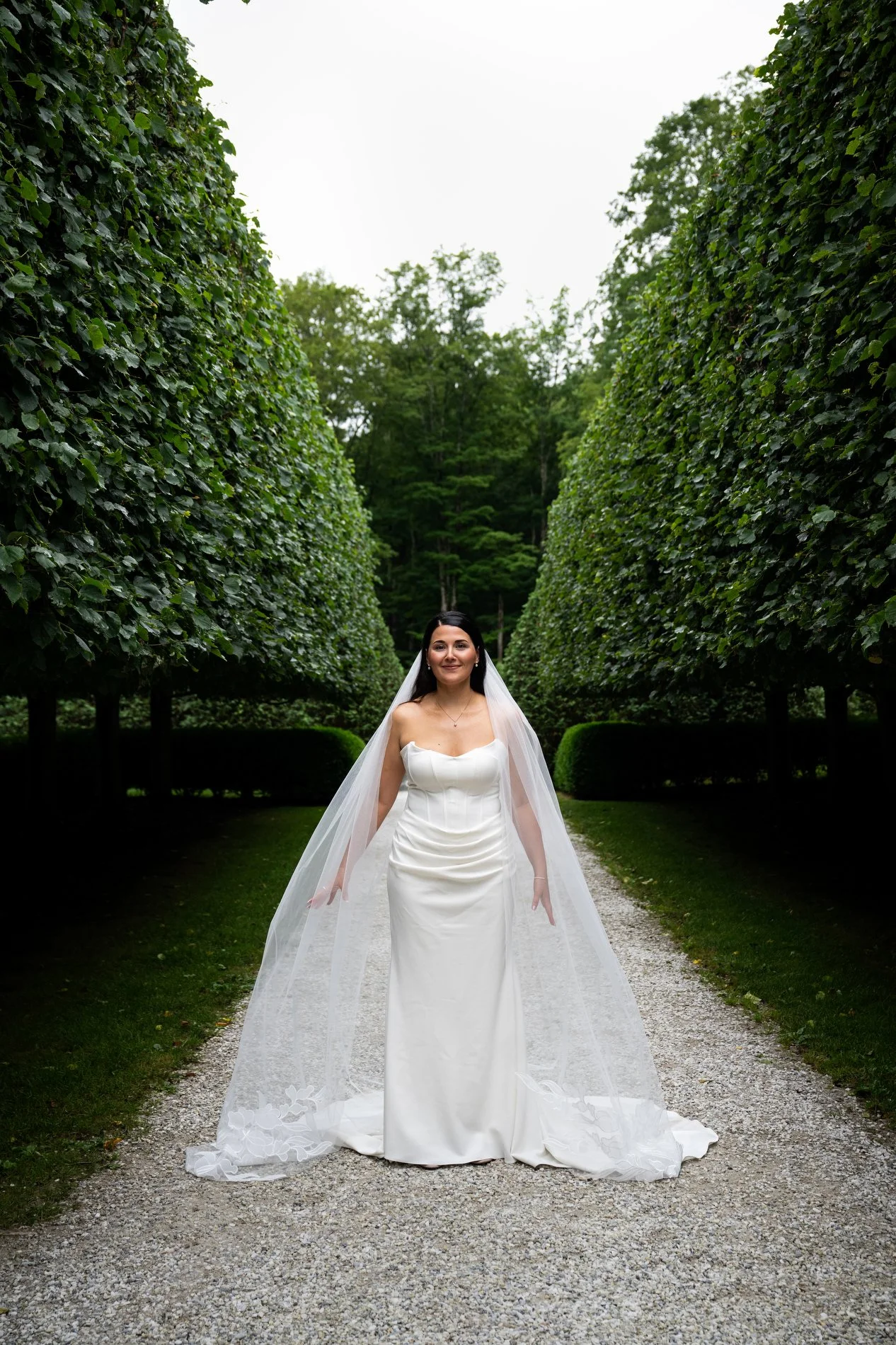A bride poses in the Lime Walk at The Mount during her romantic Berkshires wedding.