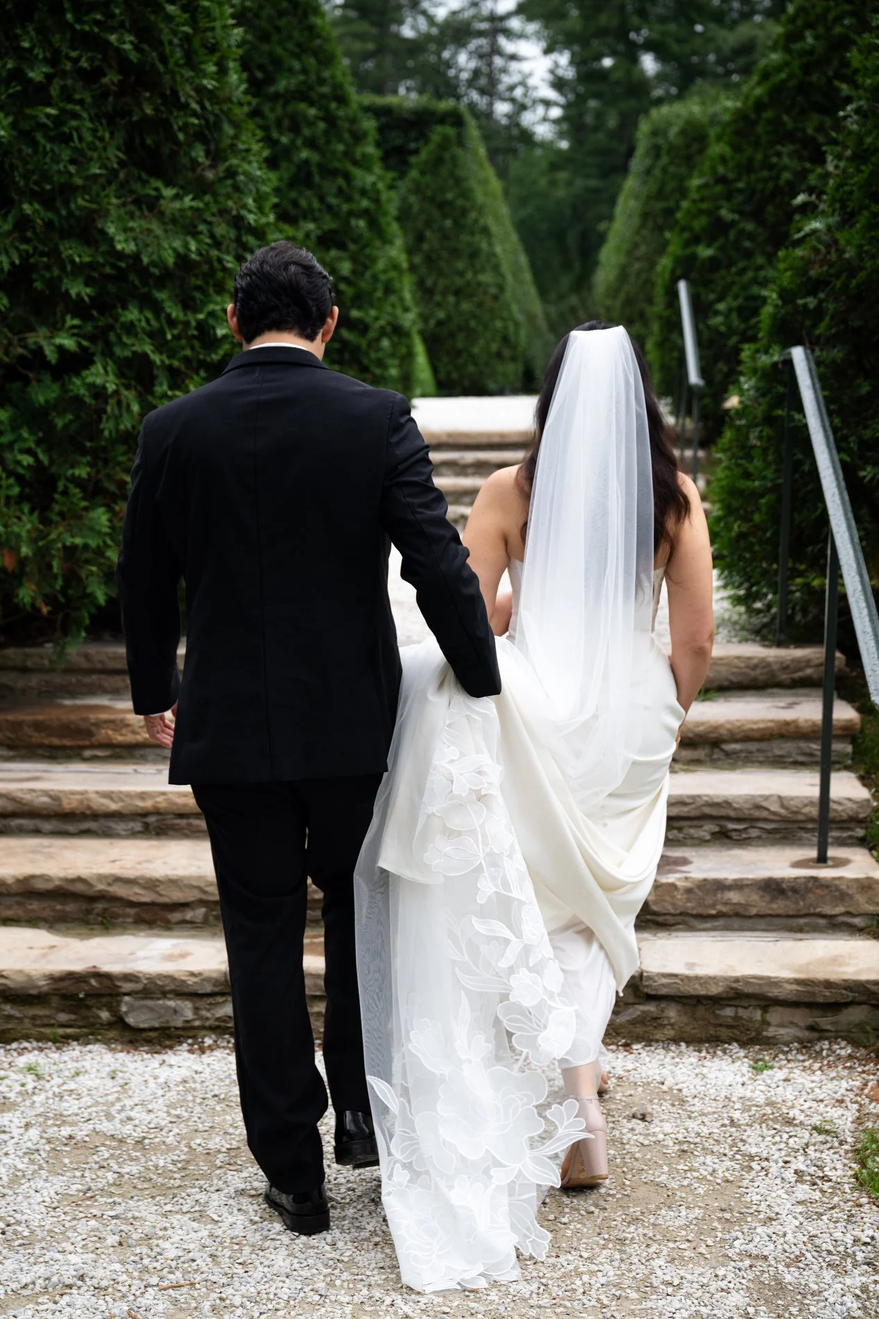 A bride and groom walk together through the Italian garden at The Mount during their romantic Berkshires wedding.