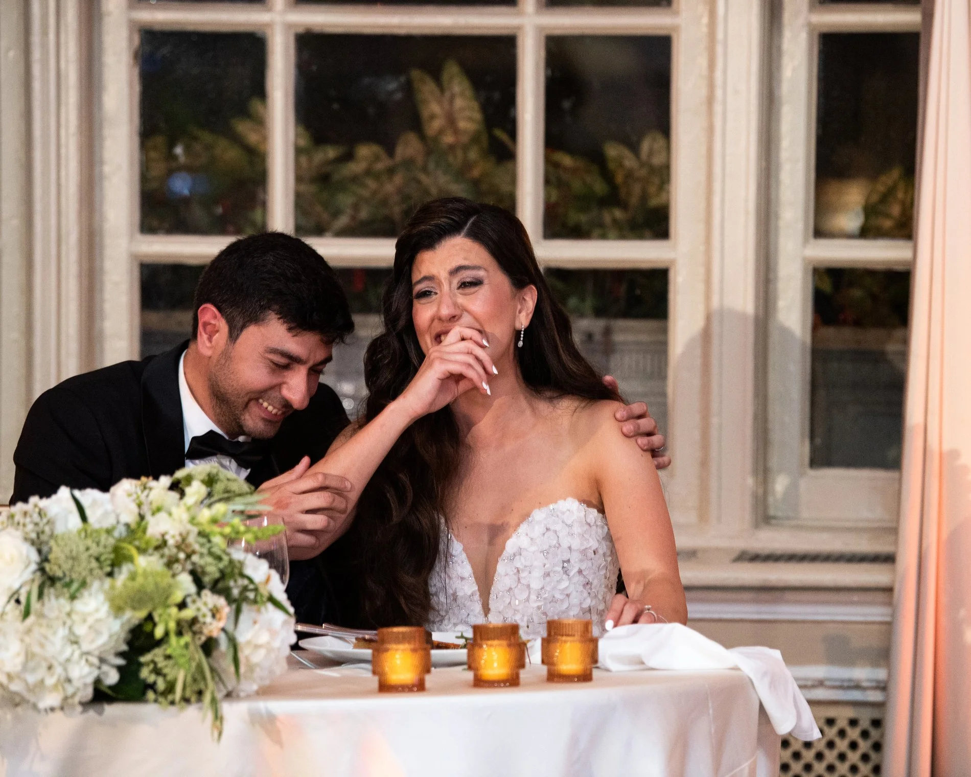 A bride and groom laugh as they are roasted during their Boston wedding photojournalism session at Fairmont Copley Plaza Hotel.