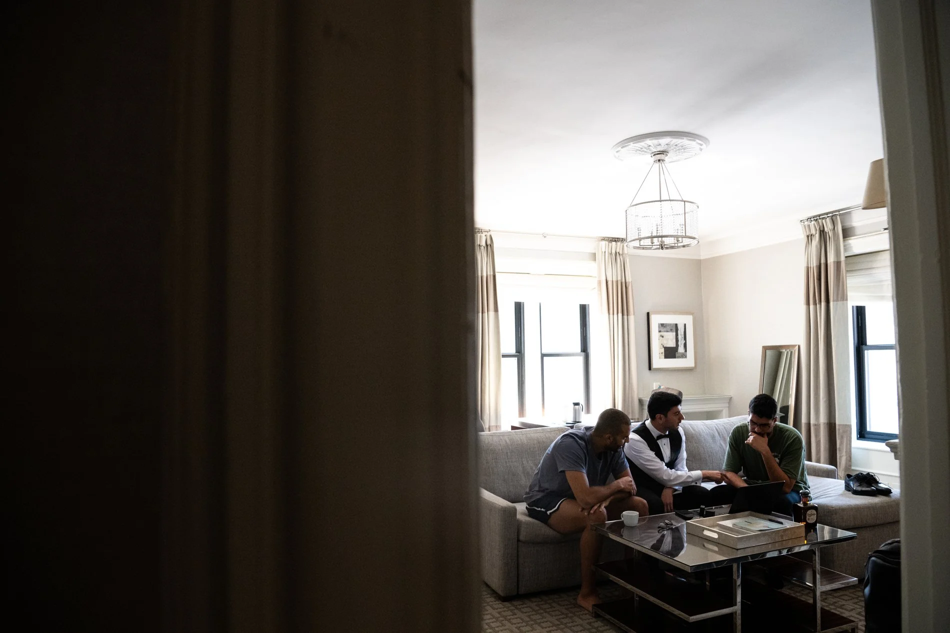 A groom and his friends go over speech plans together during a Boston documentary wedding photography session.