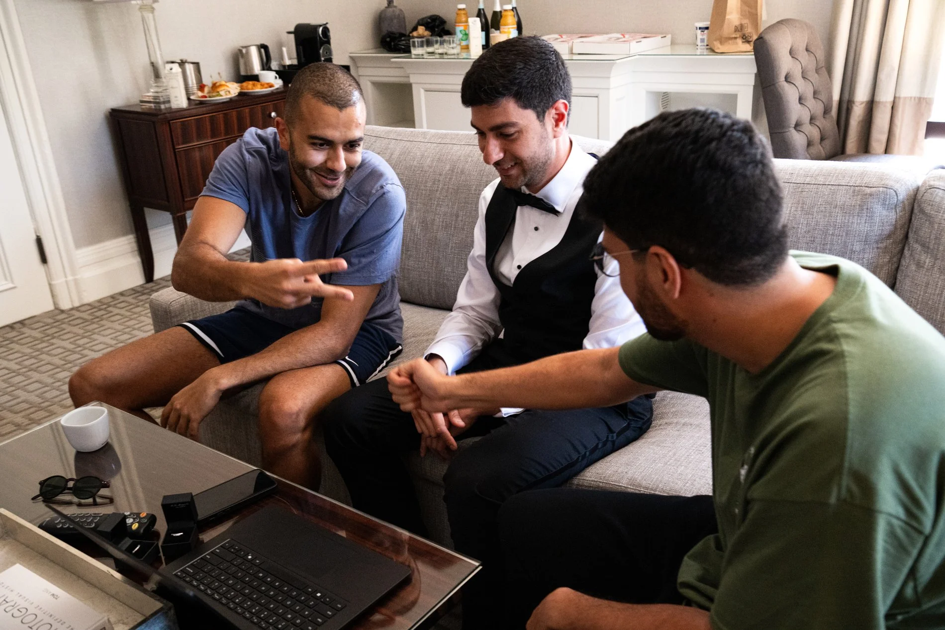 A groom and his friends enjoy some down time while getting ready for a Boston documentary wedding photography session.