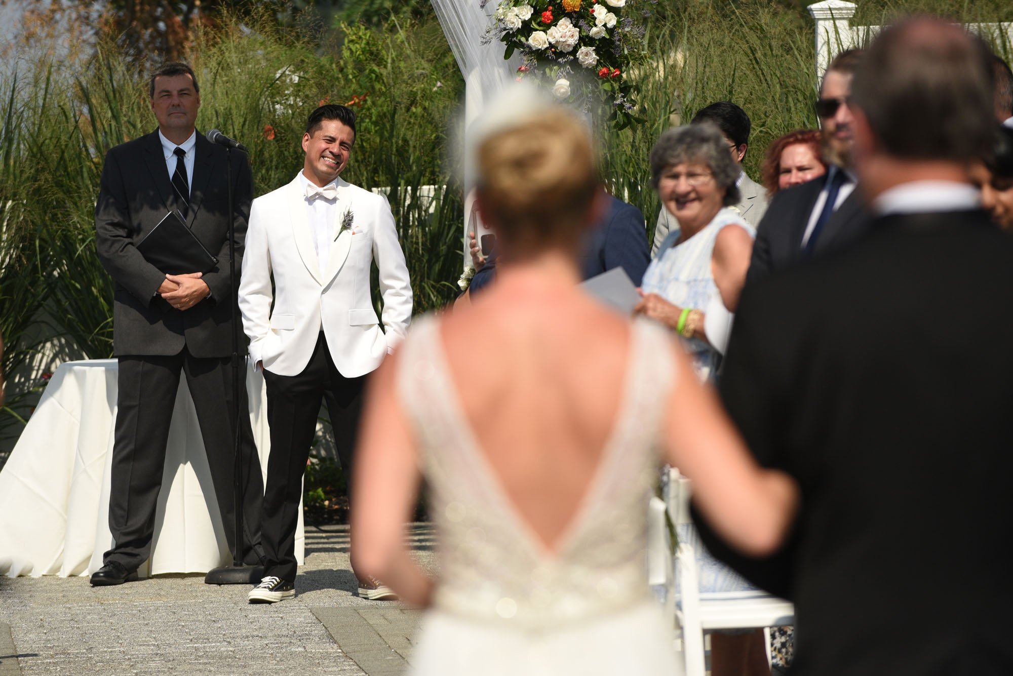 groom sees bride for the first time walking down the aisle at their long island wedding