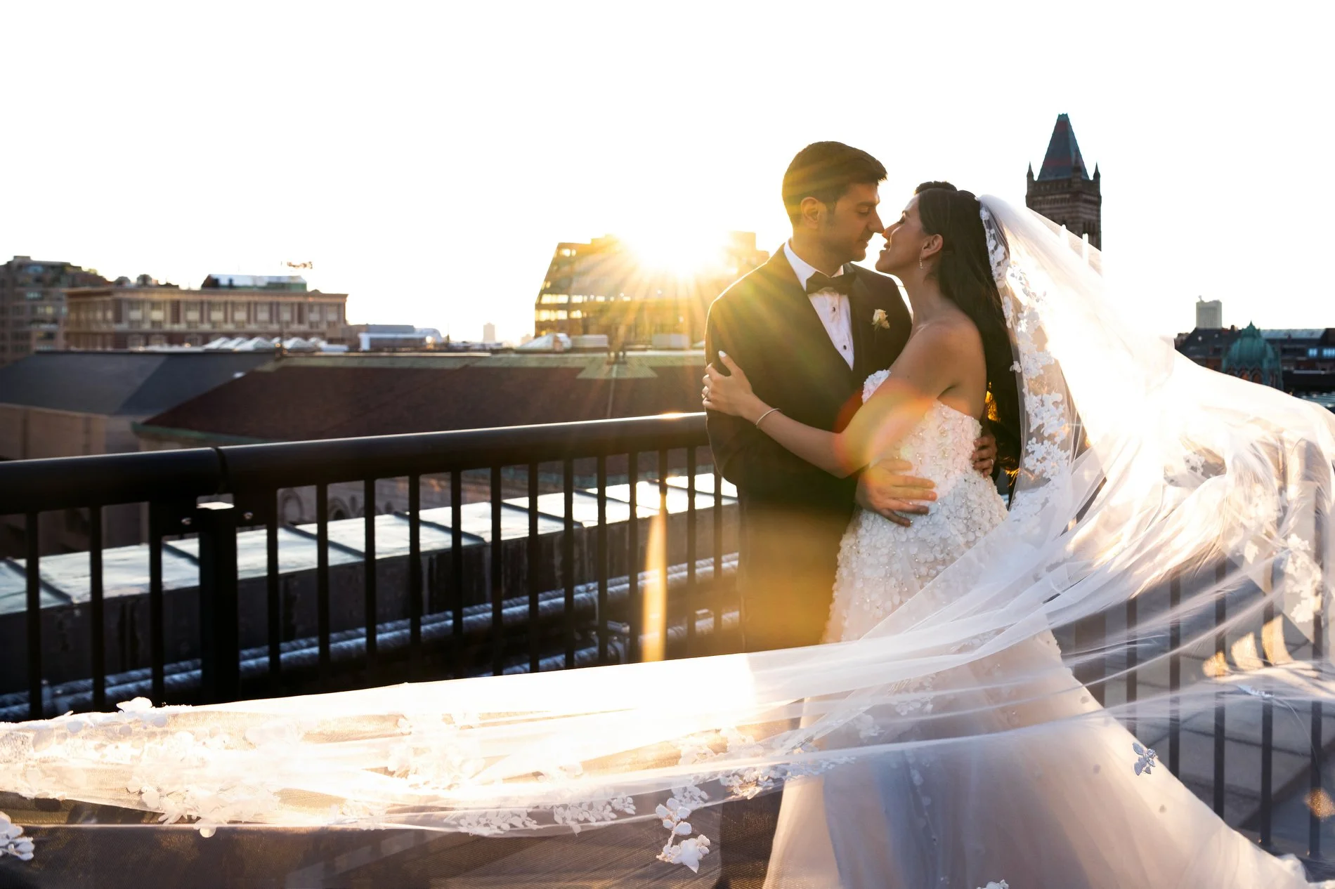 A bride and groom kiss on the roof of the Fairmont Copley Plaza Hotel in Boston during their wedding photojournalism session.
