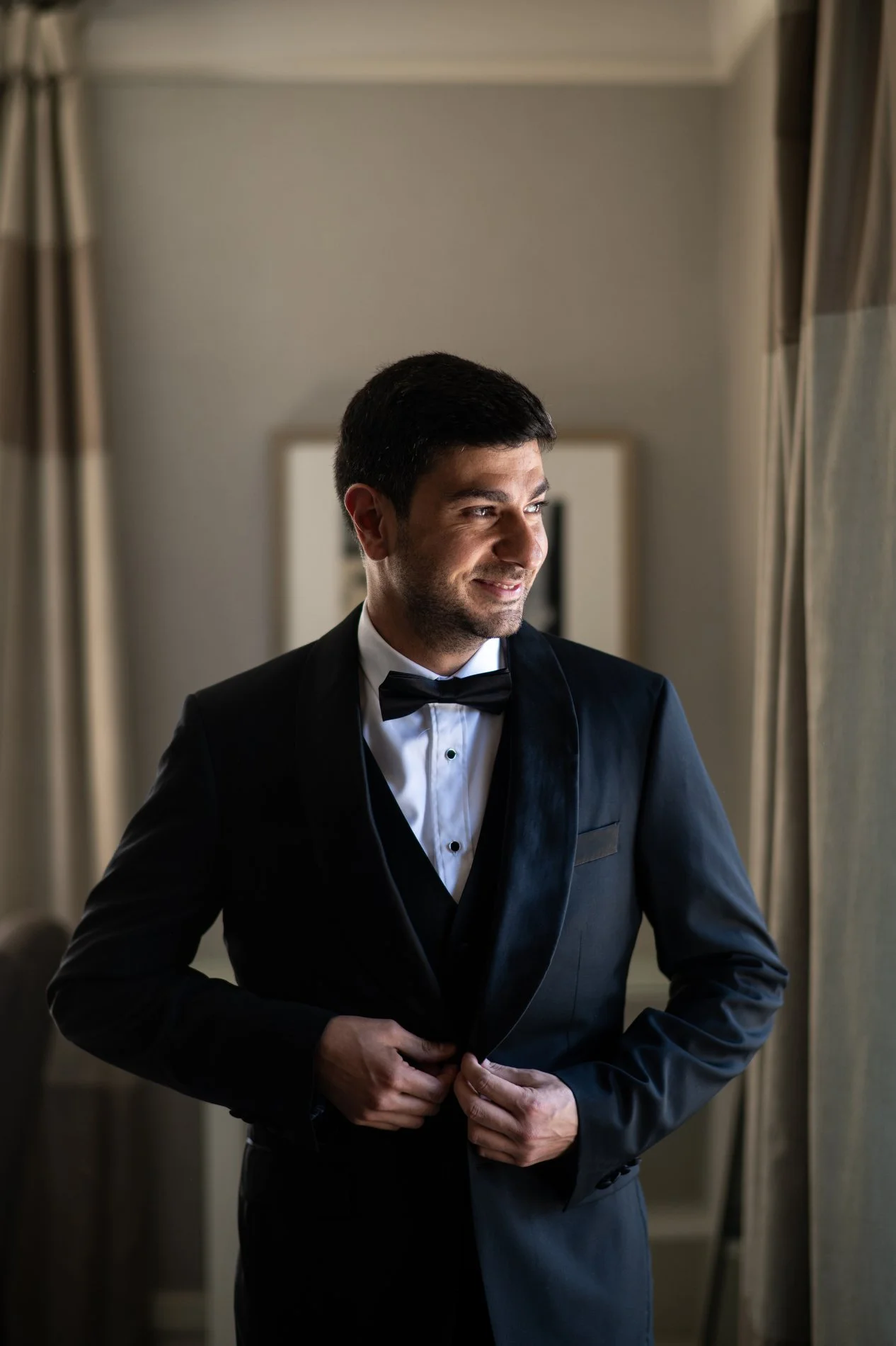 A groom gets dressed during his Boston wedding photography session.