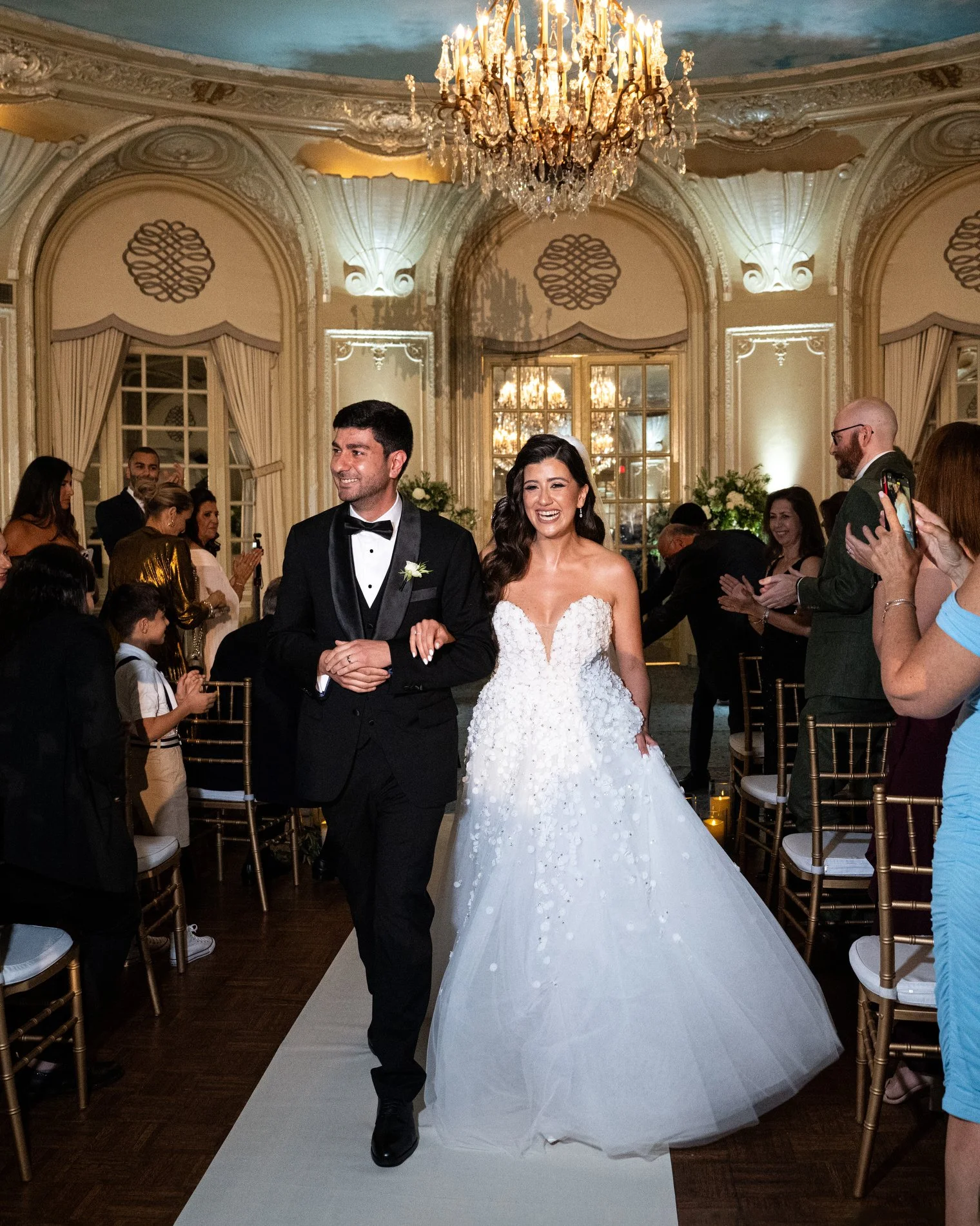 The bride and groom walk together down the aisle after getting married during their Boston hotel wedding photography session at Fairmont Copley Plaza Hotel.