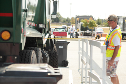  A Road-E-O judge measures the distance between the Front Loader and the rail to determine the accuracy of driver Chad Shook during the competition. 