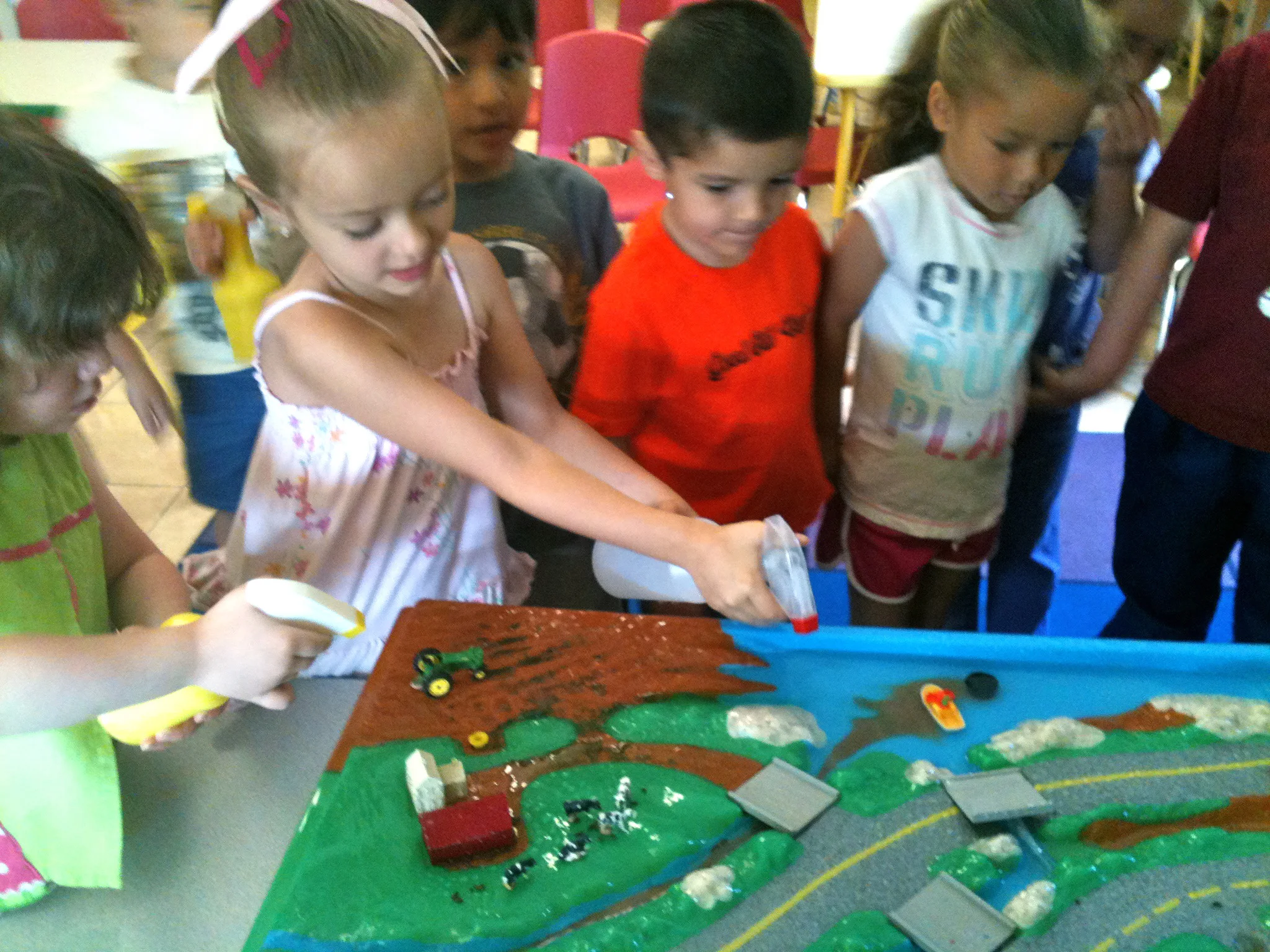 Students explore sources of water pollution using an Enviroscape watershed model during a class visit.