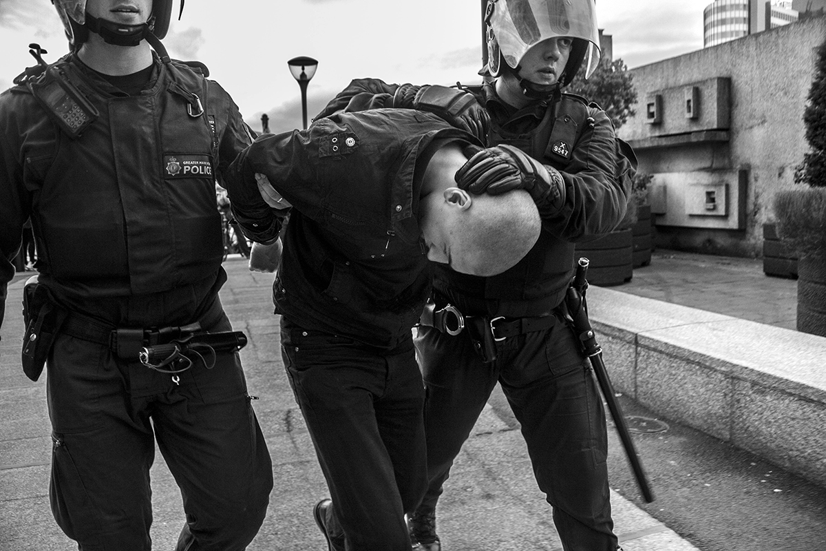 A member of the EDL is escorted away by police from a protest in Manchester. 2009.
