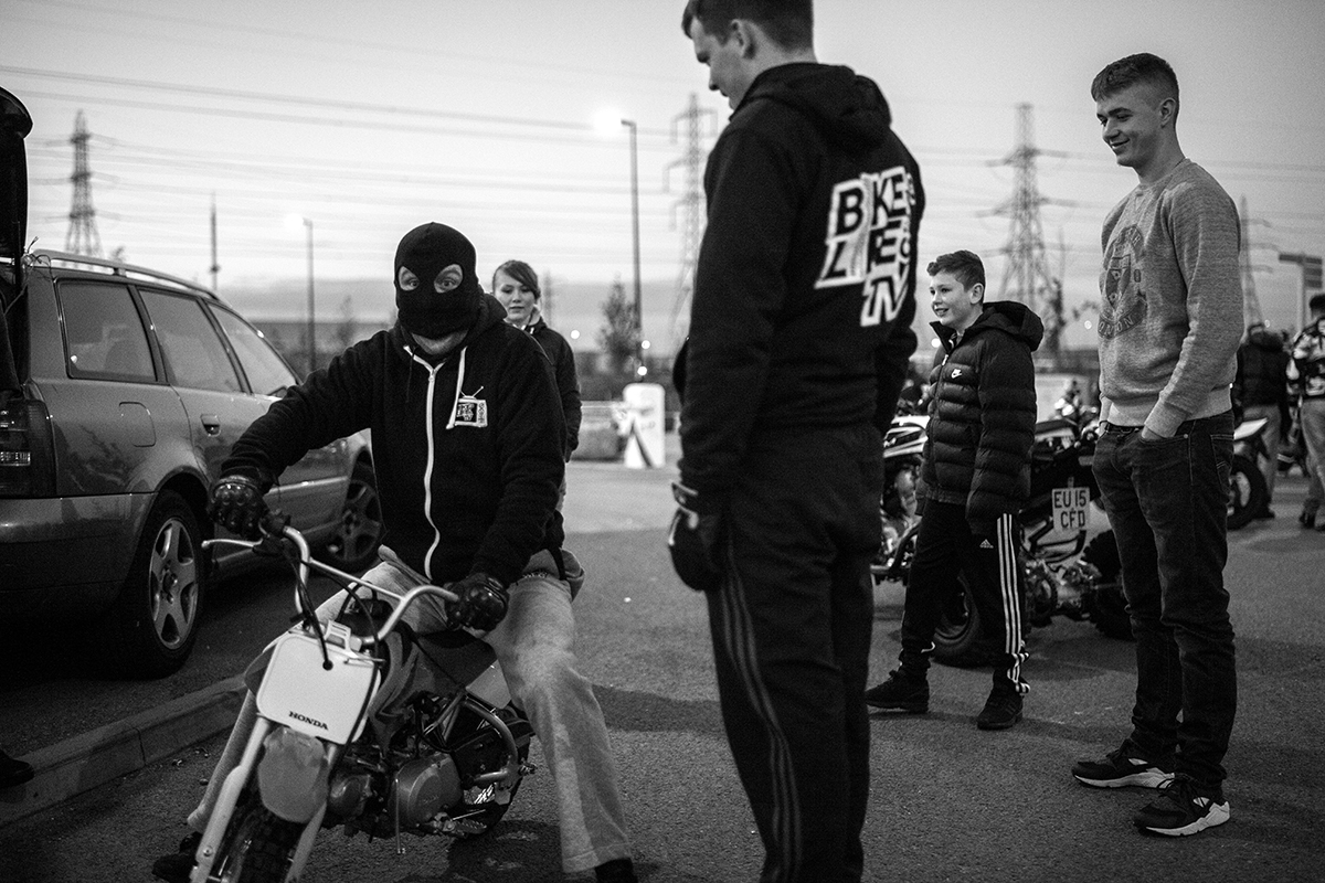 "I’ve always enjoyed riding motorbikes, but I've never really been the person to ride them on the dirt, so the bikelife scene appealed because I liked riding on flat surfaces doing stunts." Dogfather plays around on a kid's dirtbike during a Wheelie Wednesday meetup on an industrial site near Dagenham, Essex. 20/05/2015