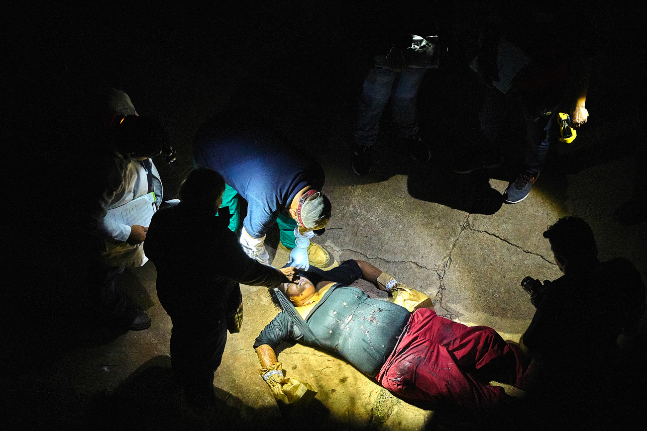  A forensic team investigates the scene of a murder in Olocuilta. Four suspected gang members approached a female sweet vendor on a secluded pathway in the Montelimar neighbourhood and shot her over 20 times after she refused to hand over her earning