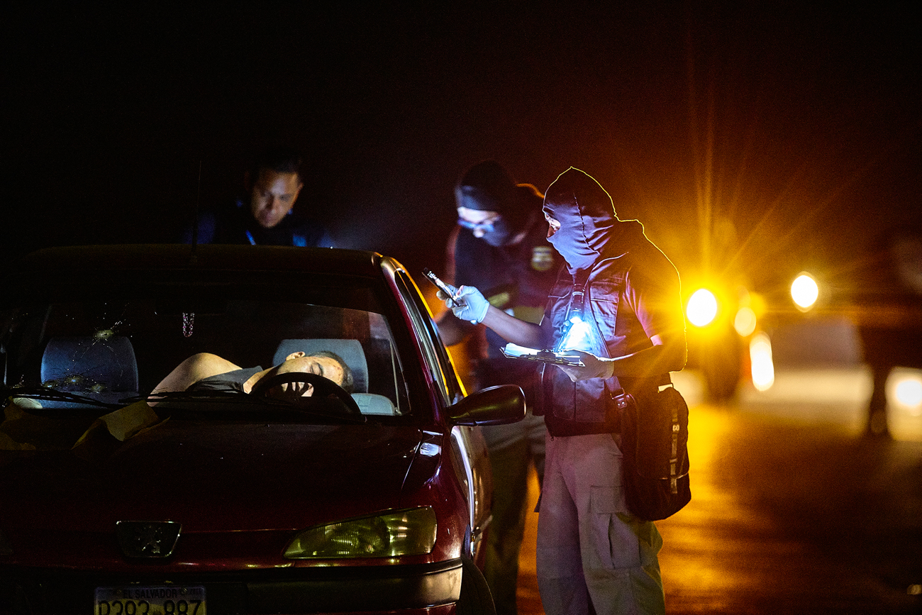  Police investigate the the murder of a man who was shot in a car on  a desolate stretch of highway between San Salvador and La Libertad. 