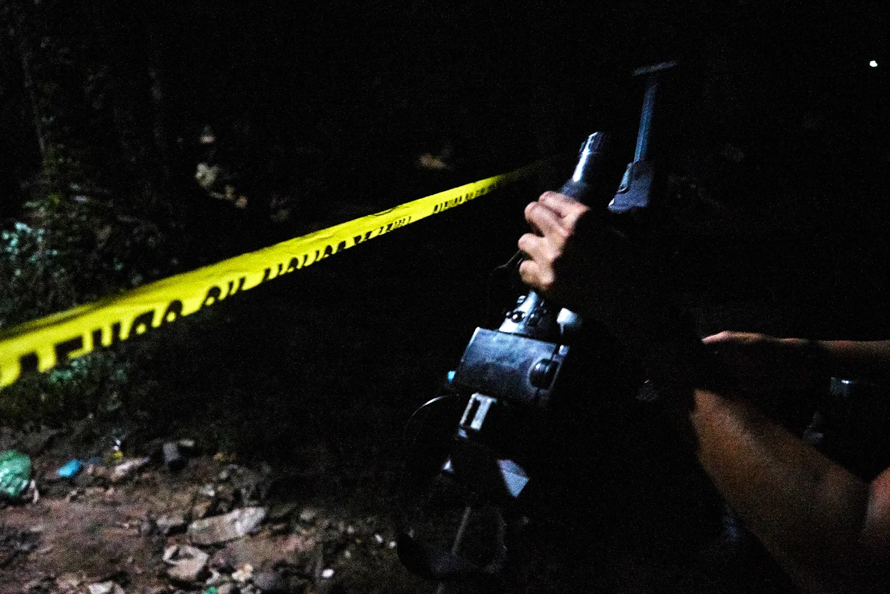  A video journalist prepares to shoot footage at a police cordon in Mejicanos.  An elderly woman was shot dead whilst sleeping in a hammock outside her home. During the same evening 16 intentional homicides were recorded across El Salvador with at le