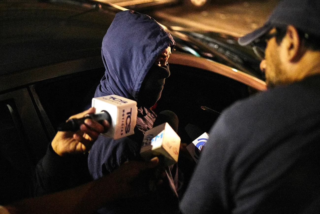  A news reporter speaks with a forensec lead investigating the shooting of a young man in a restaurant in Downtown San Salvador. 