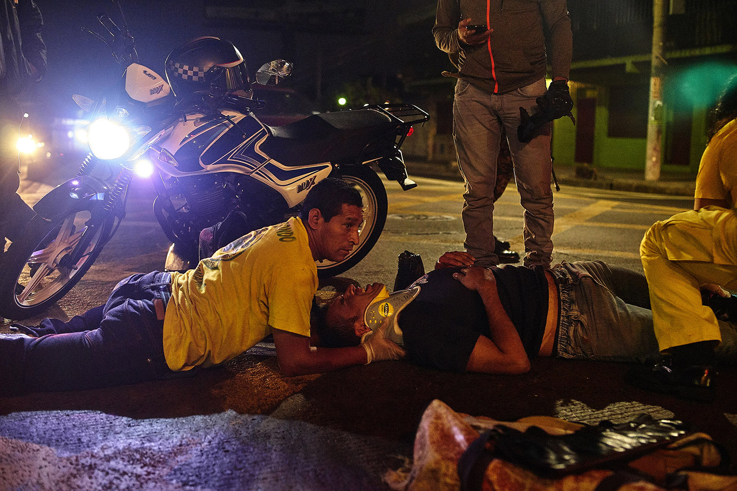Luis Pineda, 35, a paramedic with the CDS, supports the neck of a road accident victim while colleagues move the patient onto a stretcher.