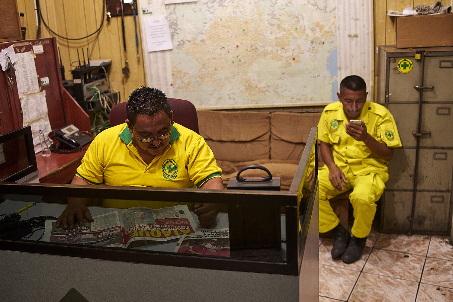 After the evening roll call, Zaldaña (44) a 15-year veteran of the Comandos De Salvamento volunteer paramedic organization, goes to man the radio. His colleague and fellow veteran volunteer, Manuel Perez, keeps him company for a while during the lul