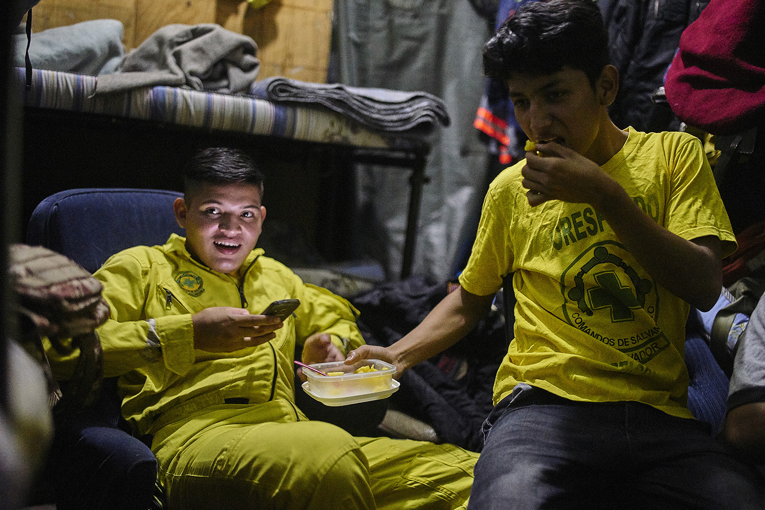 Saul Jimenez (20) and Michael Jason (18) relax with friends in their dormitory during a quiet moment on shift.