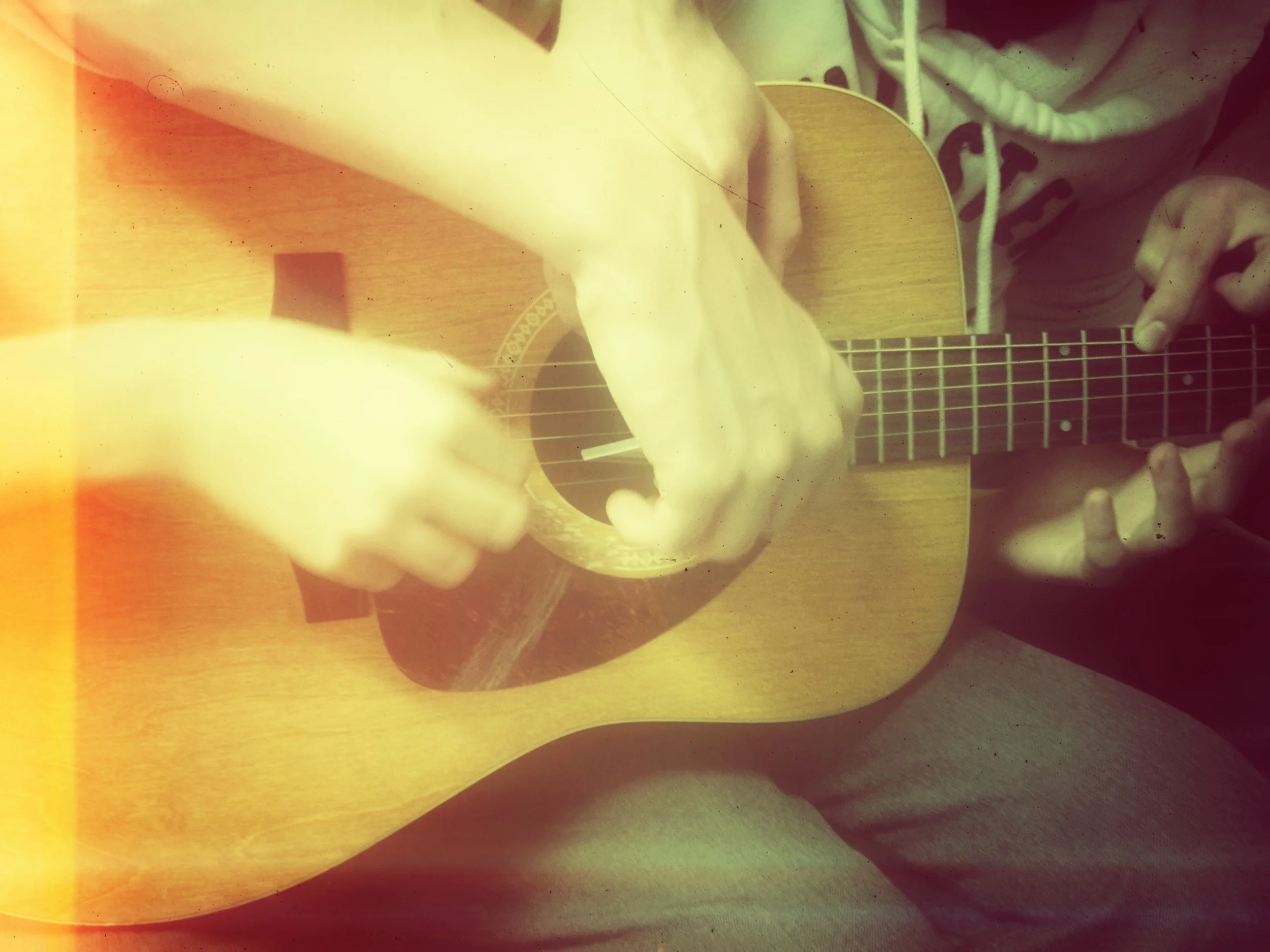 Students learning to play a guitar with 5 people!